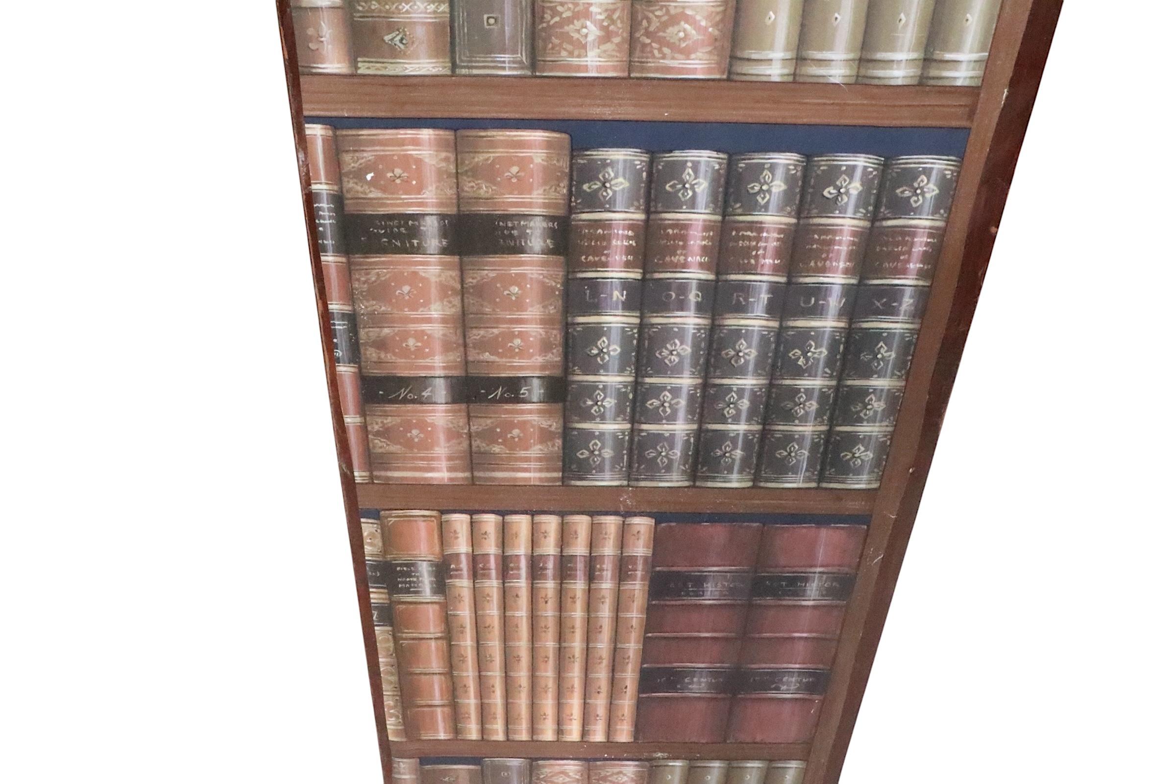Impressionante divisorio per ambienti a sei pieghe, con una finta biblioteca con libri antichi rilegati in pelle. Il paravento è costituito da sei pannelli di compensato, ciascuno di 12 pollici di lato, con superfici decorate come carta da parati.