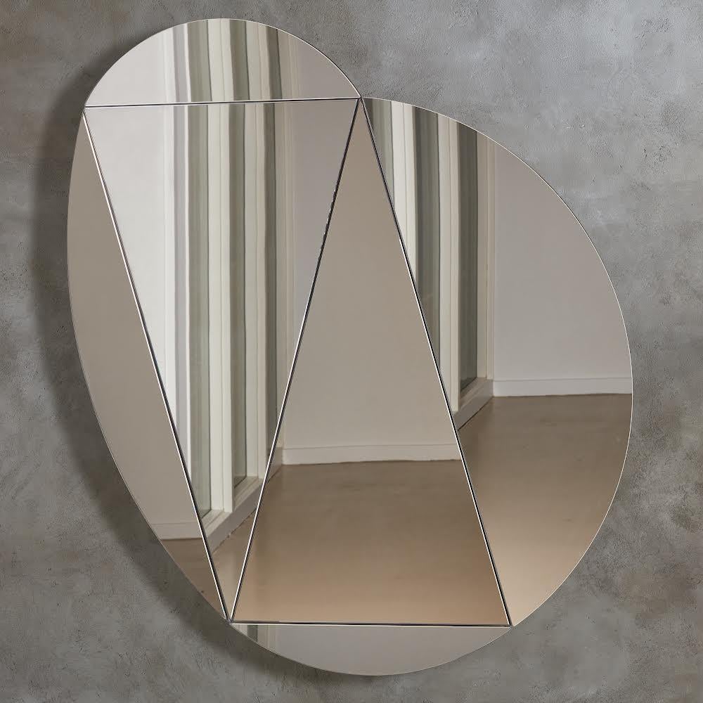 Modular mirror designed and produced by Talbot & Yoon.
 

 The Segment Mirror was imagined as a series of triangular flat mirrors framed by ‘petals’ slightly raised off the wall surface that grow across the wall surface like lilies on a pond.
 

