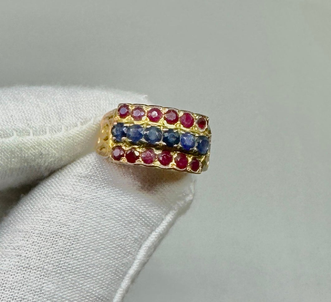 Date un capricho con un fabuloso anillo antiguo de rubí y zafiro estilo harén.  El maravilloso anillo tiene seis zafiros azules redondos facetados en el centro.  A ambos lados de los zafiros hay seis Rubíes redondos de color rojo vivo.  Los zafiros