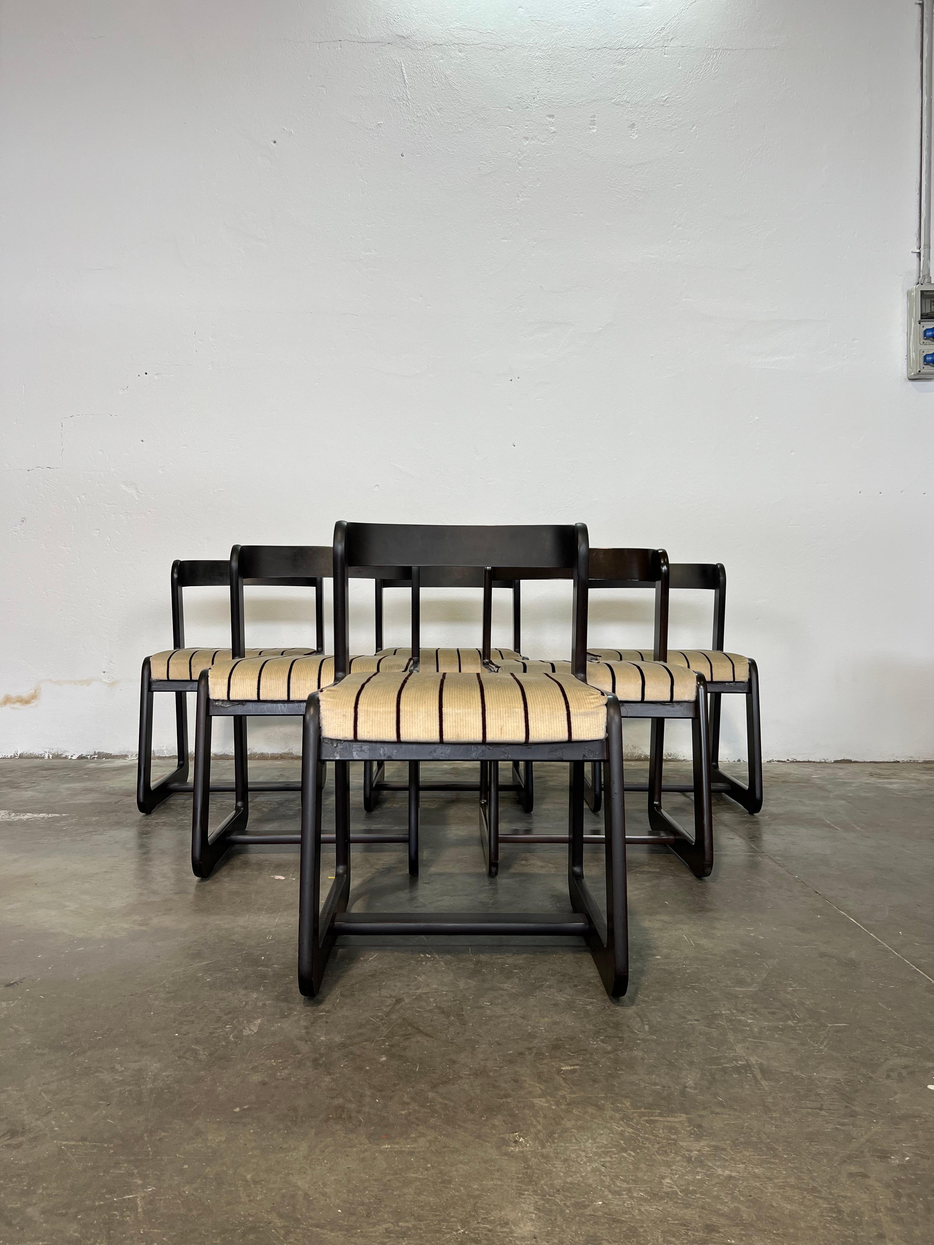This set of six dining chairs, designed by Willy Rizzo and crafted by Mario Sabot in the 1970s, embodies mid-century modern and Space Age design. The chairs feature curved wooden frames with a striking black lacquered finish, complemented by stiped