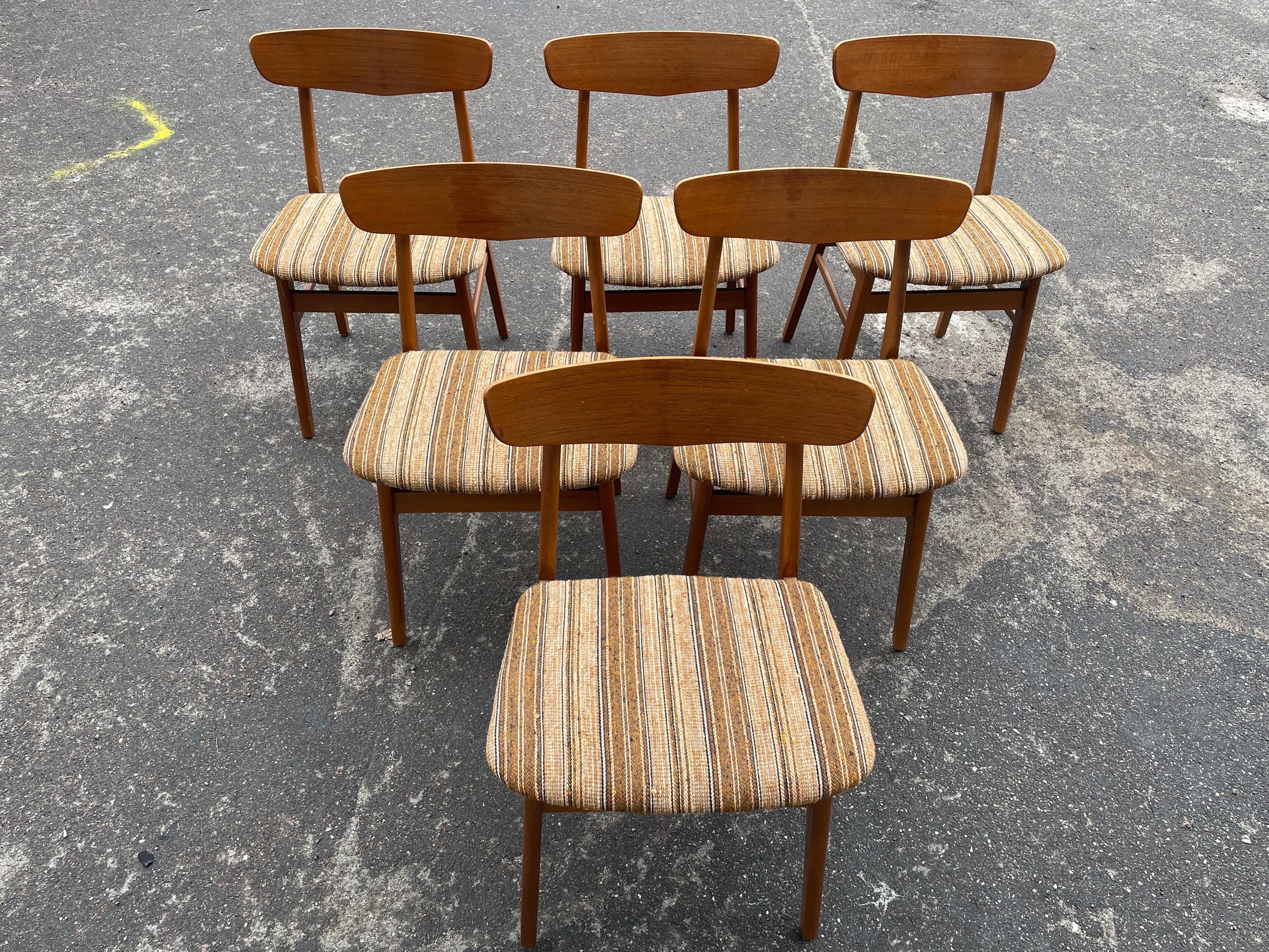 Un set di 6 sedie da pranzo in teak originale danese degli anni '60, che incarna l'eleganza moderna della metà del secolo. Realizzate in resistente teak, queste sedie sono caratterizzate da linee pulite e da un design senza tempo, che mette in