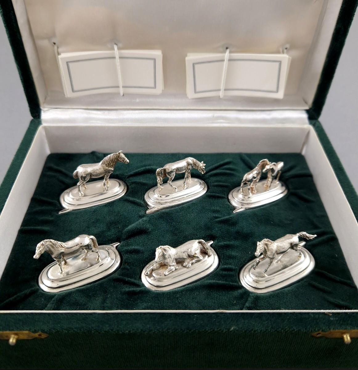 Satz von sechs Tischkartenhaltern aus Sterlingsilber mit Pferdedarstellungen. 
Länge: 4.3 cm 
Breite: 2.1 cm 
Höhe: zwischen 1,8 und 3,3 cm 
Gesamtgewicht: 87 Gramm.
800 Silber Punzierung
Mit Originalverpackung