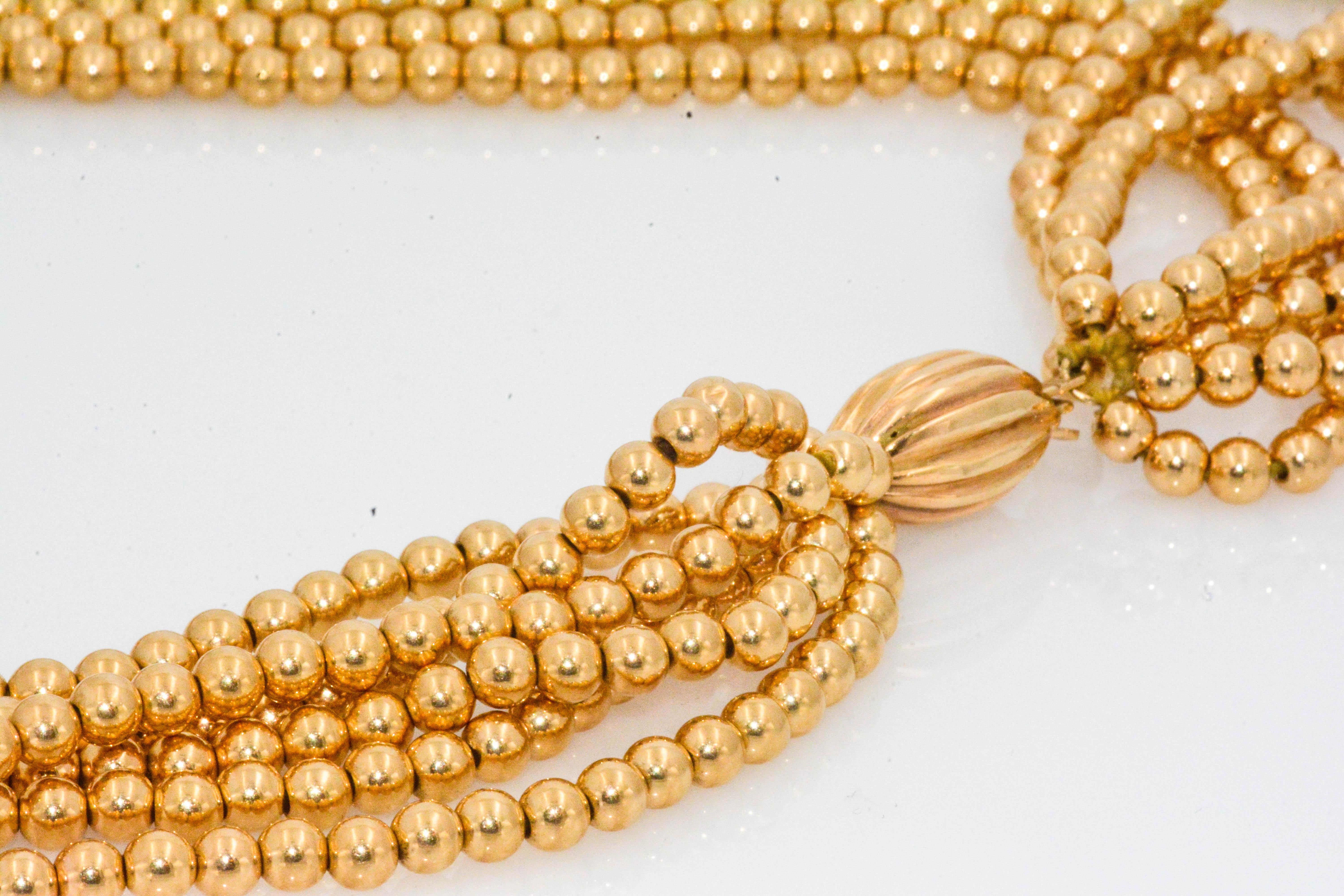 Presenting six strands of high polish 14 karat yellow gold beads in a 32 inch necklace. Feathery, light, and graceful.; this classic gold bead necklace is Circa 1980's.  Featuring an enchanting grooved 14 karat gold clasp.