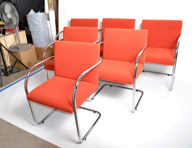 Set of Ludwig Mies van der Rohe attributed Brno armchairs or dining room chairs in original coral red fabric upholstery. 
Solid chrome tubular frames with cantilever swing, very comfortable.
Marked with original paper tag under the seat, Gordon
