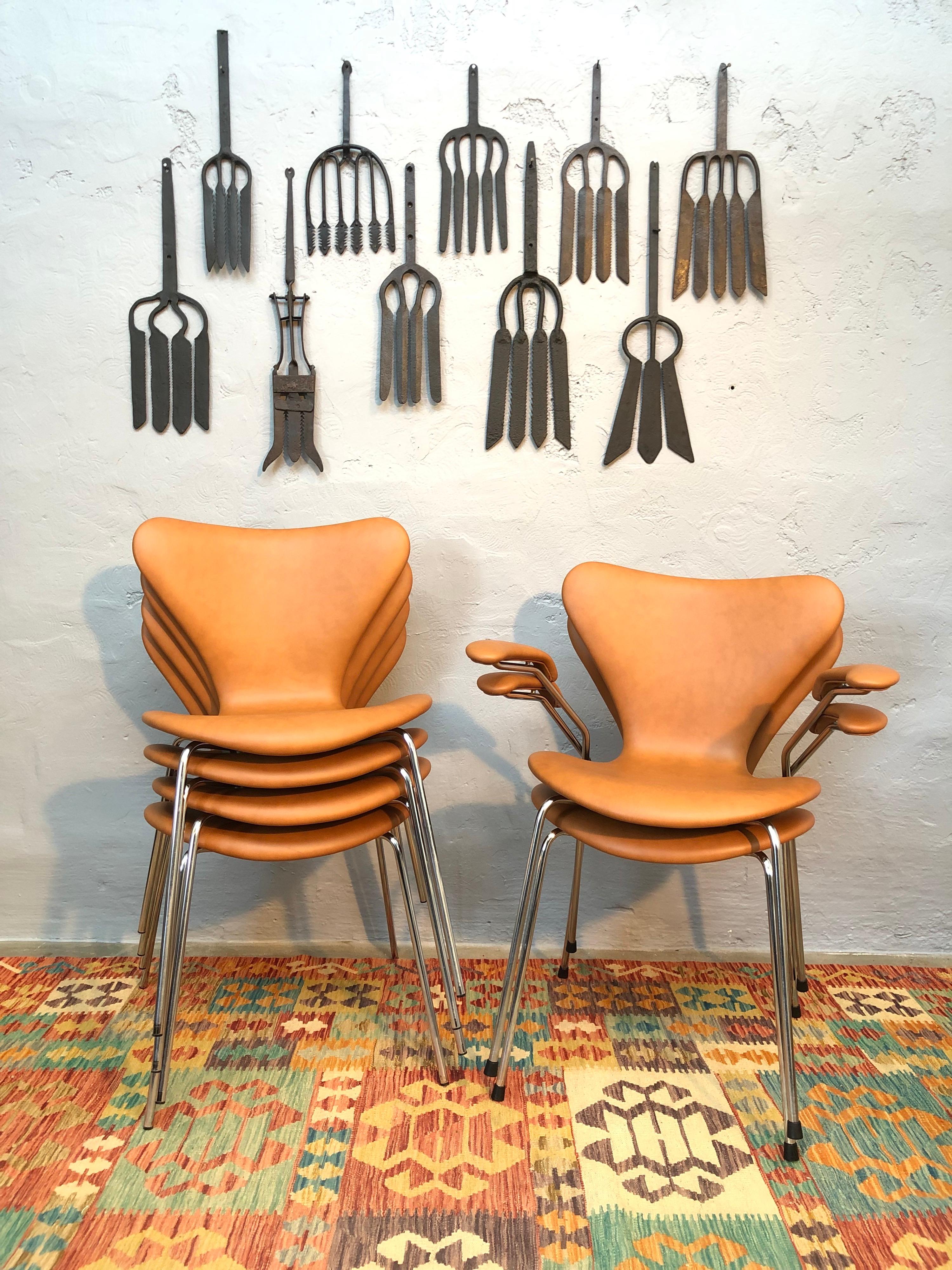 A set of 6 iconic chairs by Arne Jacobsen for Fritz Hansen of Denmark from the early 1980s. 
The set is comprised of 4 chairs model 3107 without arm rests and 2 chairs model 3207 with arm rests. 
These chairs are 40 years old and are in great