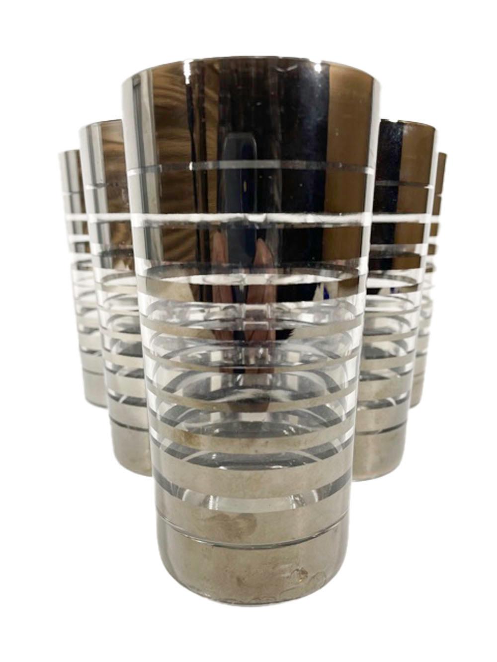 Mid-Century Modern highball glasses with silver bands starting wider at top and bottom and becoming narrower as they approach the glasses center.