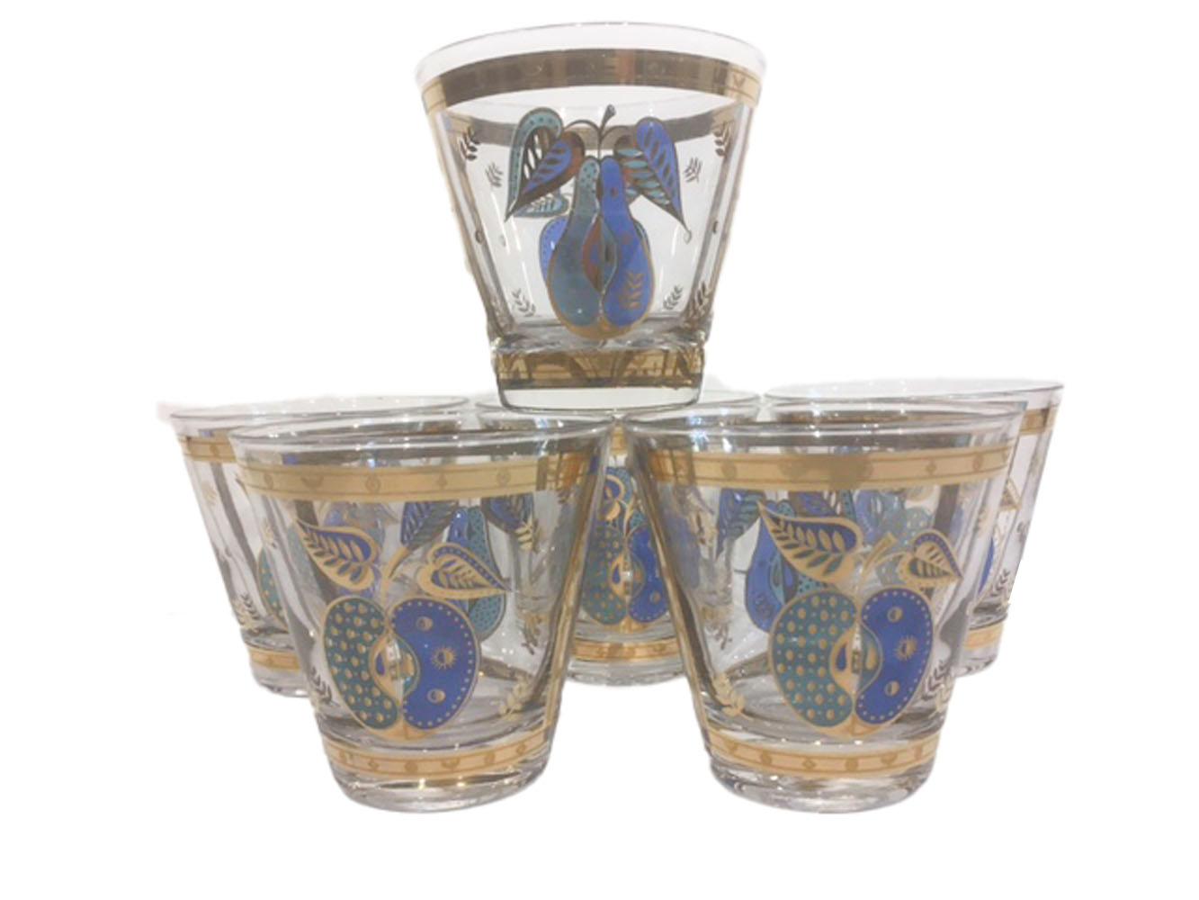 Set of six Mid-Century Modern old fashioned glasses by Georges Briard in the Forbidden Fruit pattern. Each of clear glass decorated in translucent blue and green enamel and 22 karat gold. Each glass has a pear on one side and an apple on the other