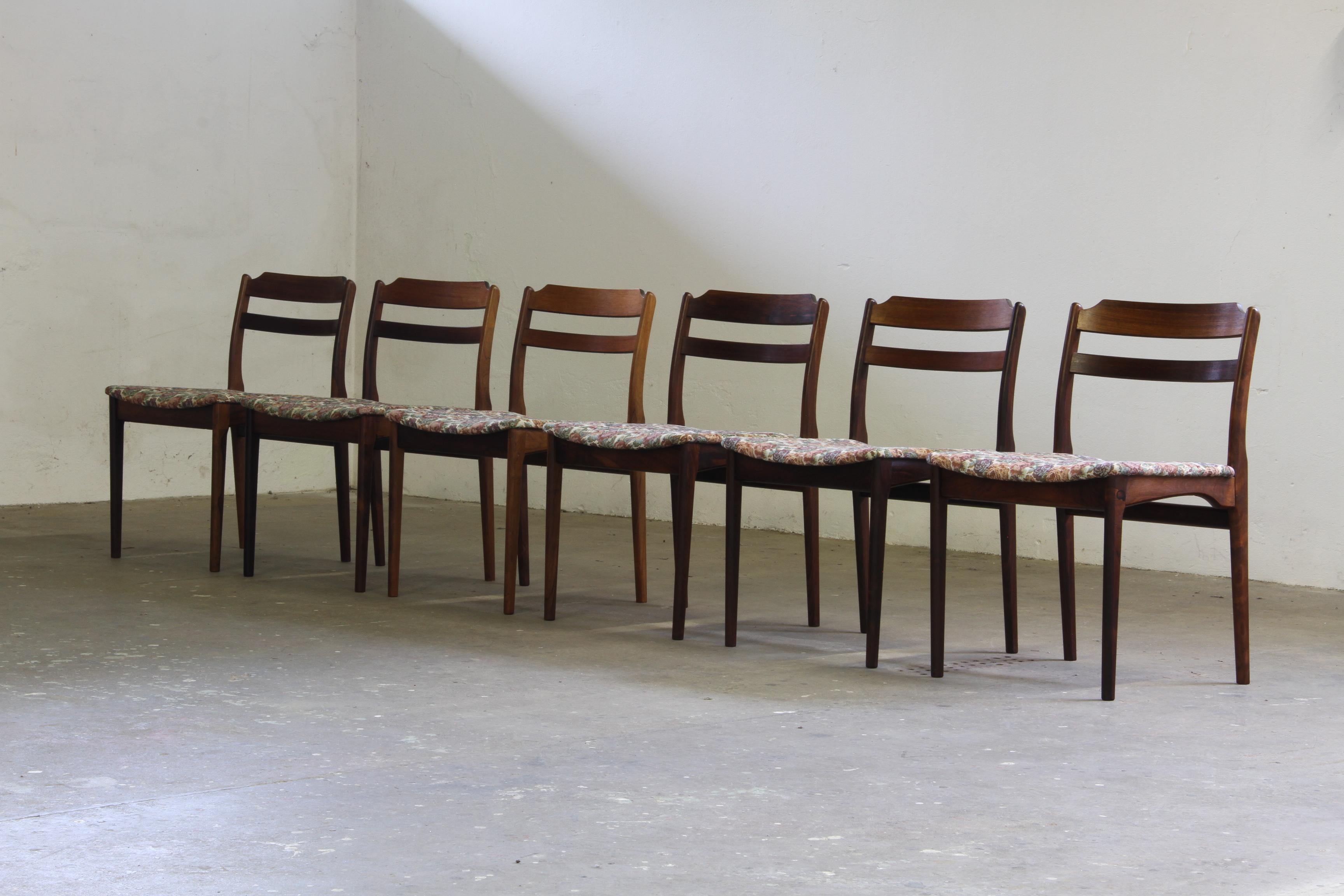 Wir präsentieren einen Satz von sechs elegant gefertigten Rosenholzstühlen der 1960er Jahre aus der Mitte des Jahrhunderts von der renommierten dänischen Möbelfabrik 