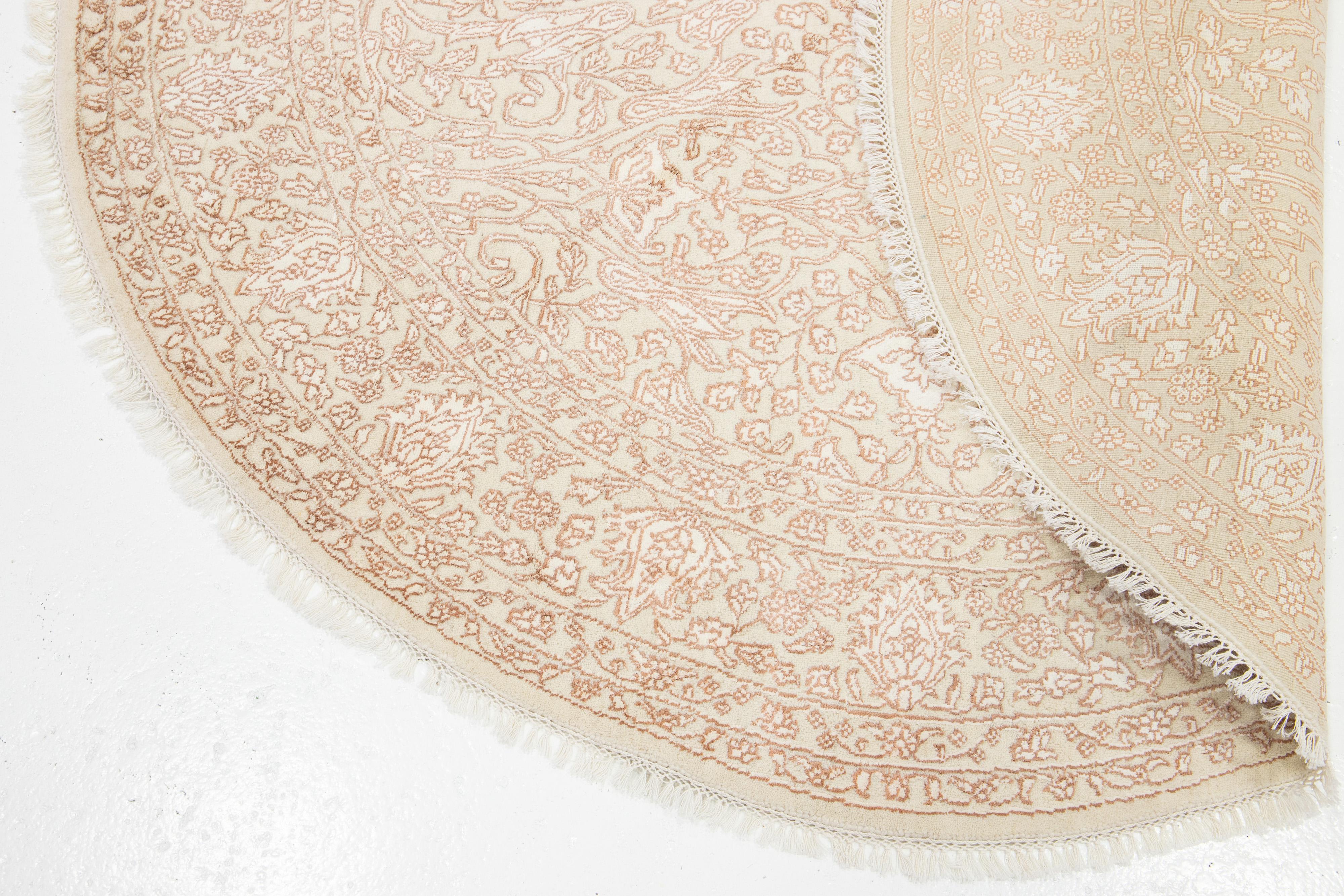 This beautiful contemporary round rug is hand-knotted from a blend of wool and silk, featuring a stunning beige color palette. With elegant ivory and copper accents, it's all-over floral design brings an artistic touch to any space.

This rug has a
