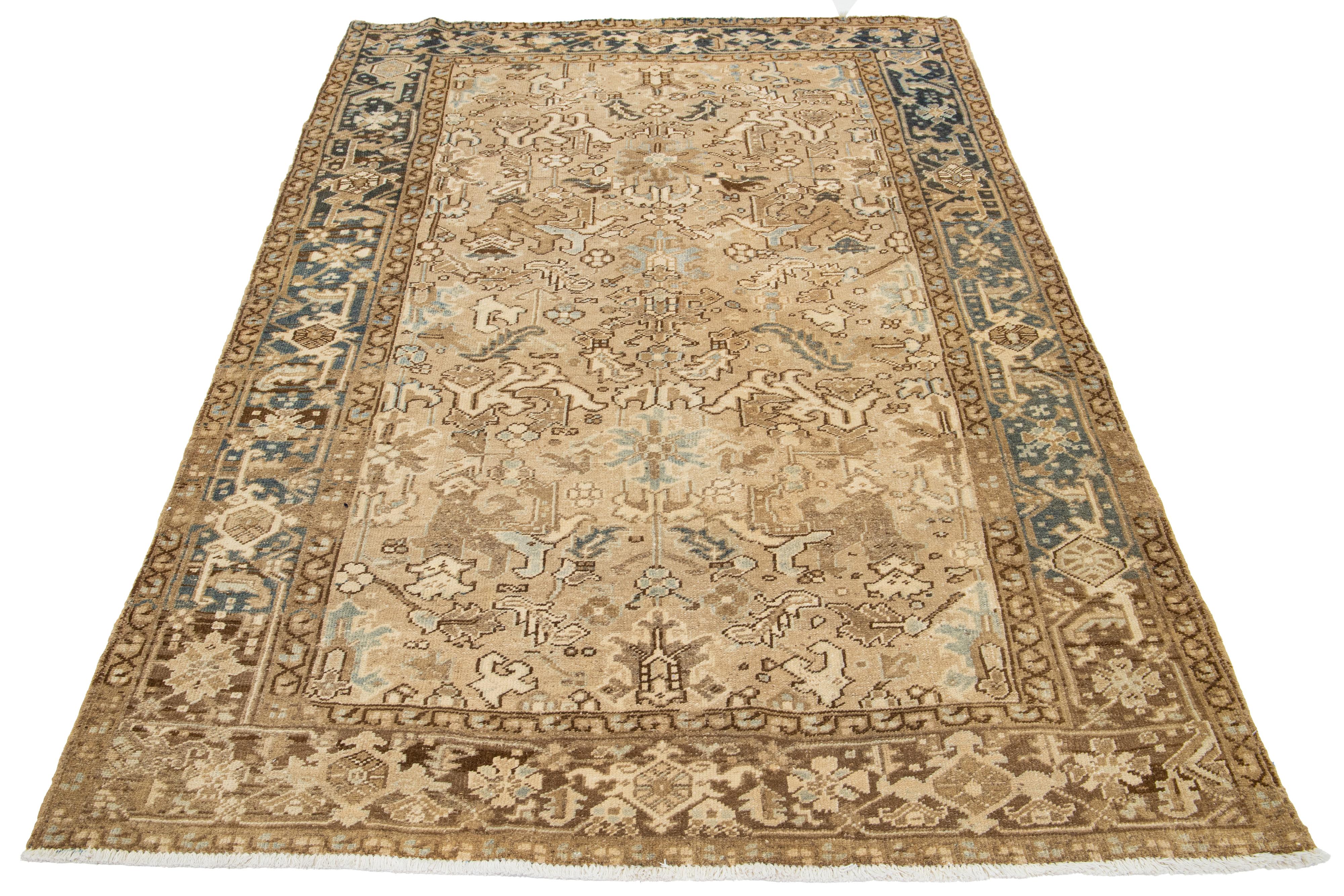 An antique Heriz rug from Persia is hand-knotted using wool. It features a beige field with a blue and brown all-over pattern.

This rug measures 5'11' x 8'10