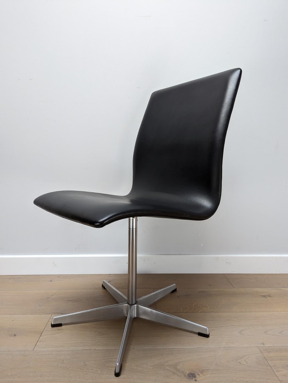 A set of 4 mid-century black Arne Jacobsen Oxford swivel dining chairs. (2 have been sold since photos were taken)

Designed by Fritz Hansen and made in Denmark by Arne Jacobsen.

Leatherette/Vinyl Seat with a chrome base and aluminium feet.

About