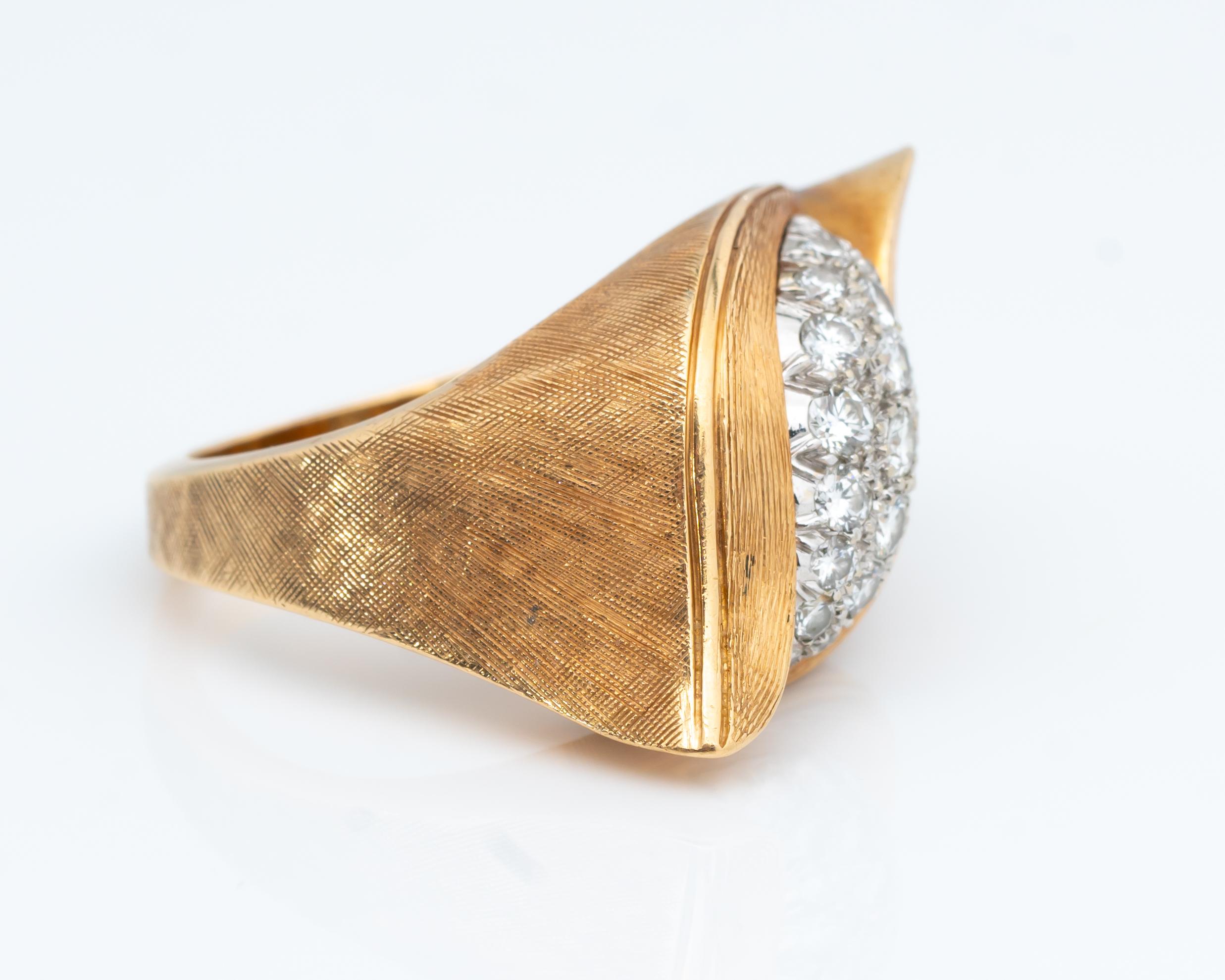 Beautifully crafted swoop ring featuring diamonds and 14 karat yellow gold. The gold has a unique minimal textured appearance and feel to it, giving the ring a very chic finish! The top view has a 