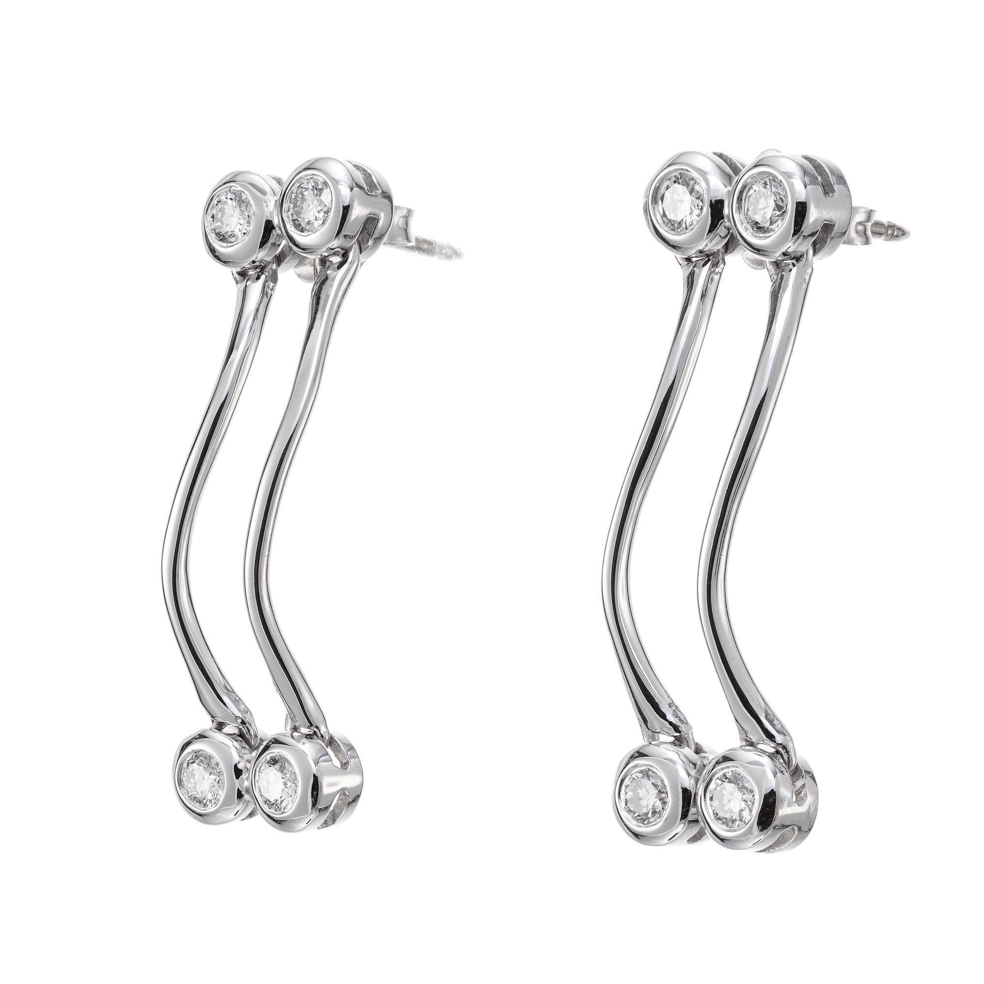 Two row swirl design diamond dangle earrings. 8 round brilliant cut diamonds.  

8 round brilliant cut diamonds, G-H VS approx. .60cts
18k white gold 
Stamped: 18k
5.5 grams
Top to bottom: 29.3mm or 1 1/8 Inch
Width: 9.1mm or 1/3 Inch
Depth or