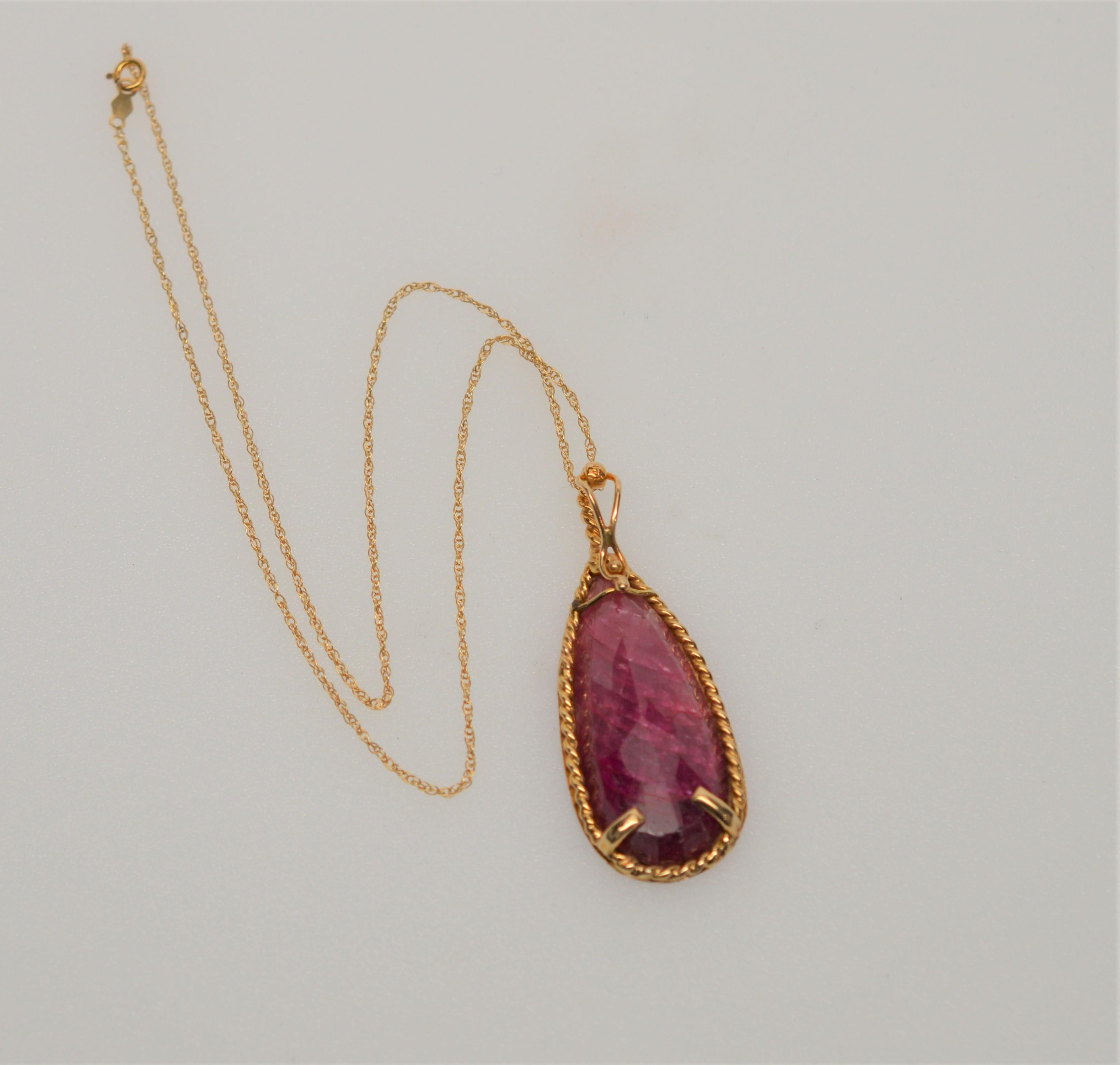 Unusual, this boldly attractive fuschia pink pear-shaped natural Ruby Pendant is framed in a 14K Yellow Gold Rope and sits at the collar on a
16 inch 14K Yellow Gold Chain.  The medium-light color stone is approximately 60 carats. The pendant