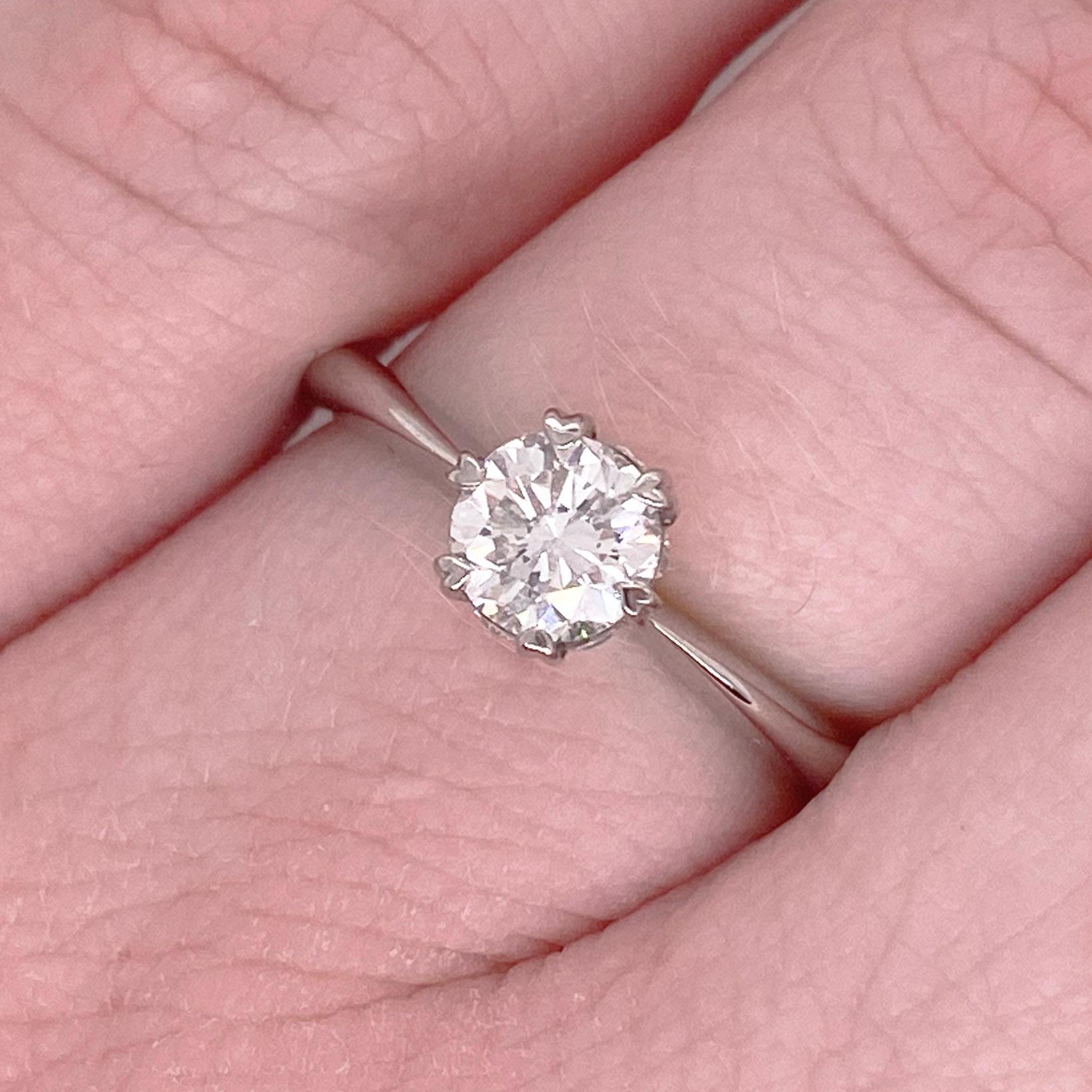 Gorgeous round brilliant cut diamond solitaire engagement ring! This gorgeous center diamond is set in six heart shaped prongs with a hidden halo. The platinum engagement ring is the perfect compliment to this stunning round diamond. Very stunning