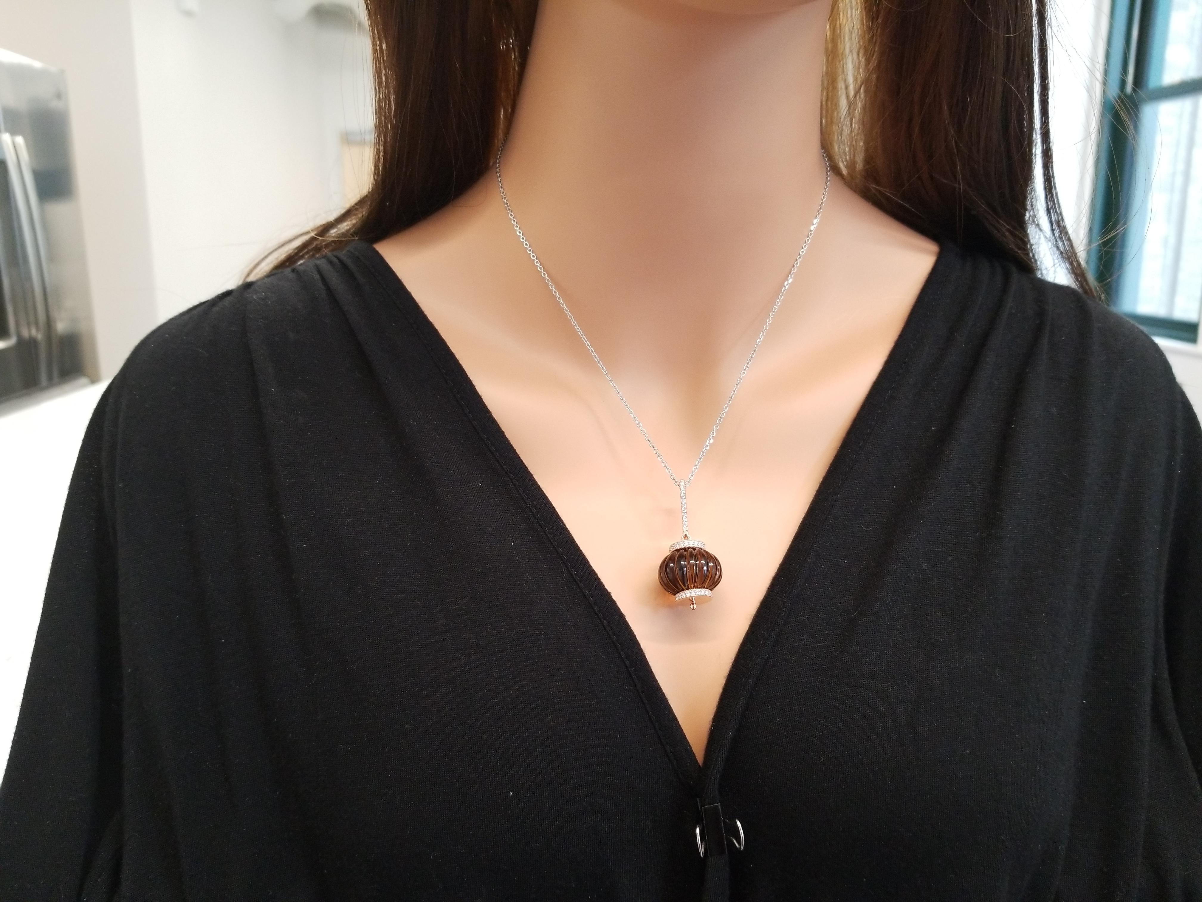 A 60 carat hand-carved, barrel shaped smoky quartz gem is an absolutely chic and fun necklace. The gem source is Brazil. Sparkling round brilliant cut diamonds are bead set in roundels hugging the impressive gem as well as diamonds fashioned linear