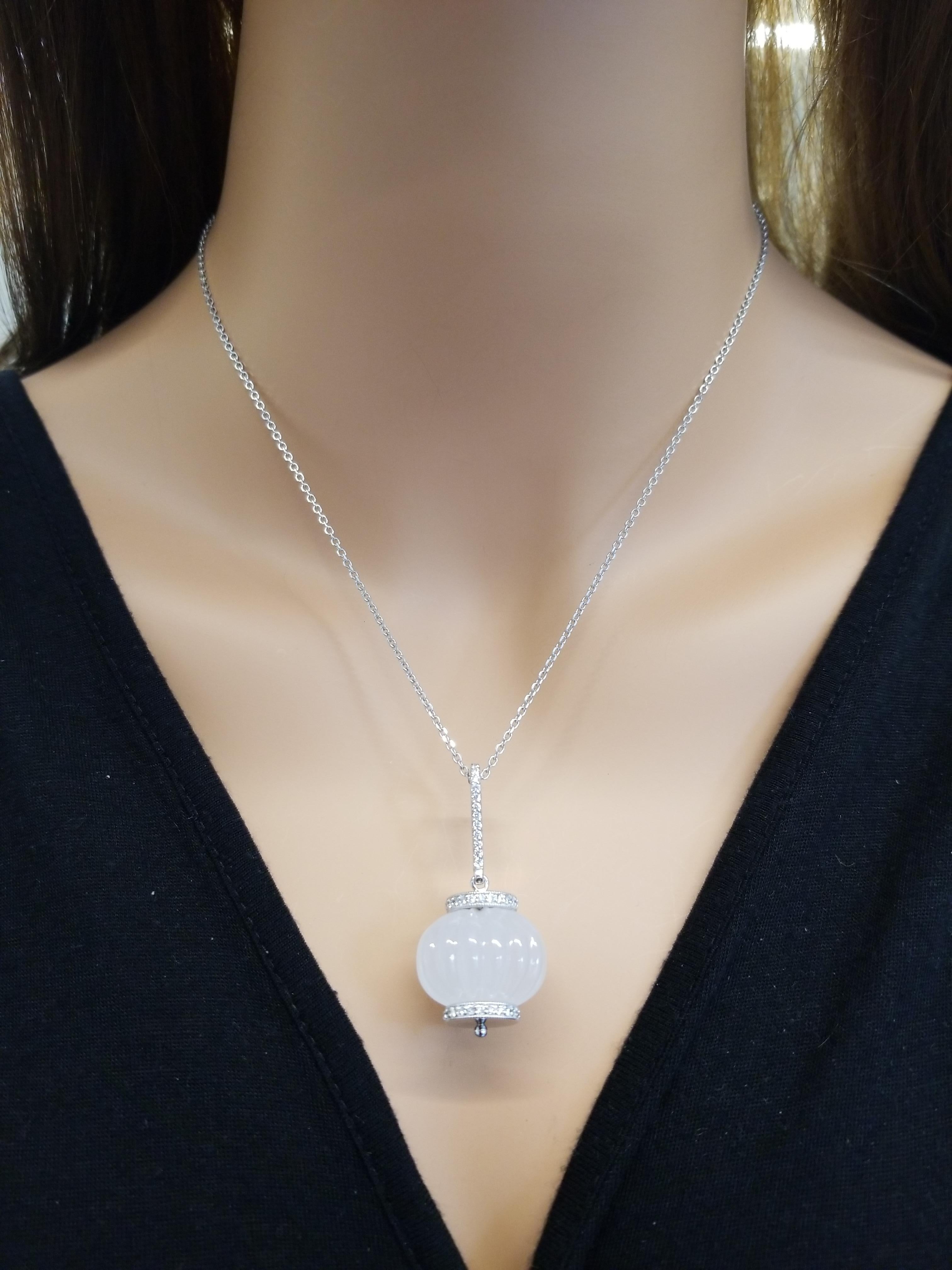 A 60 carat hand-carved, barrel shaped white quartz gem is an absolutely chic and fun necklace. The gem source is Brazil. Sparkling round brilliant cut diamonds are bead set in roundels hugging the impressive gem as well as diamonds fashioned linear