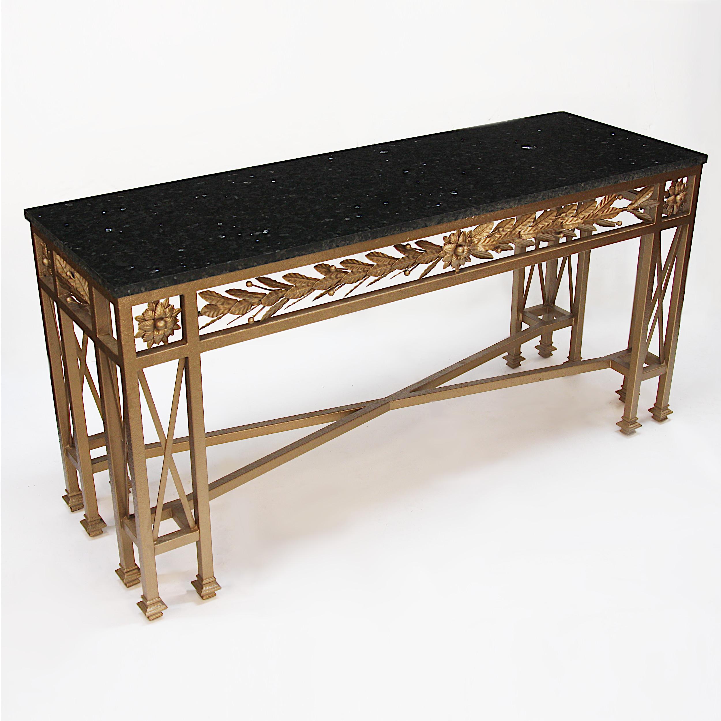 Impressive 1950s era, neoclassical style console table. Table features a heavy wrought iron base with flower and sheaf motifs, gold paint and black marble top. With its grand proportions and classic black and gold color combo, this table would make