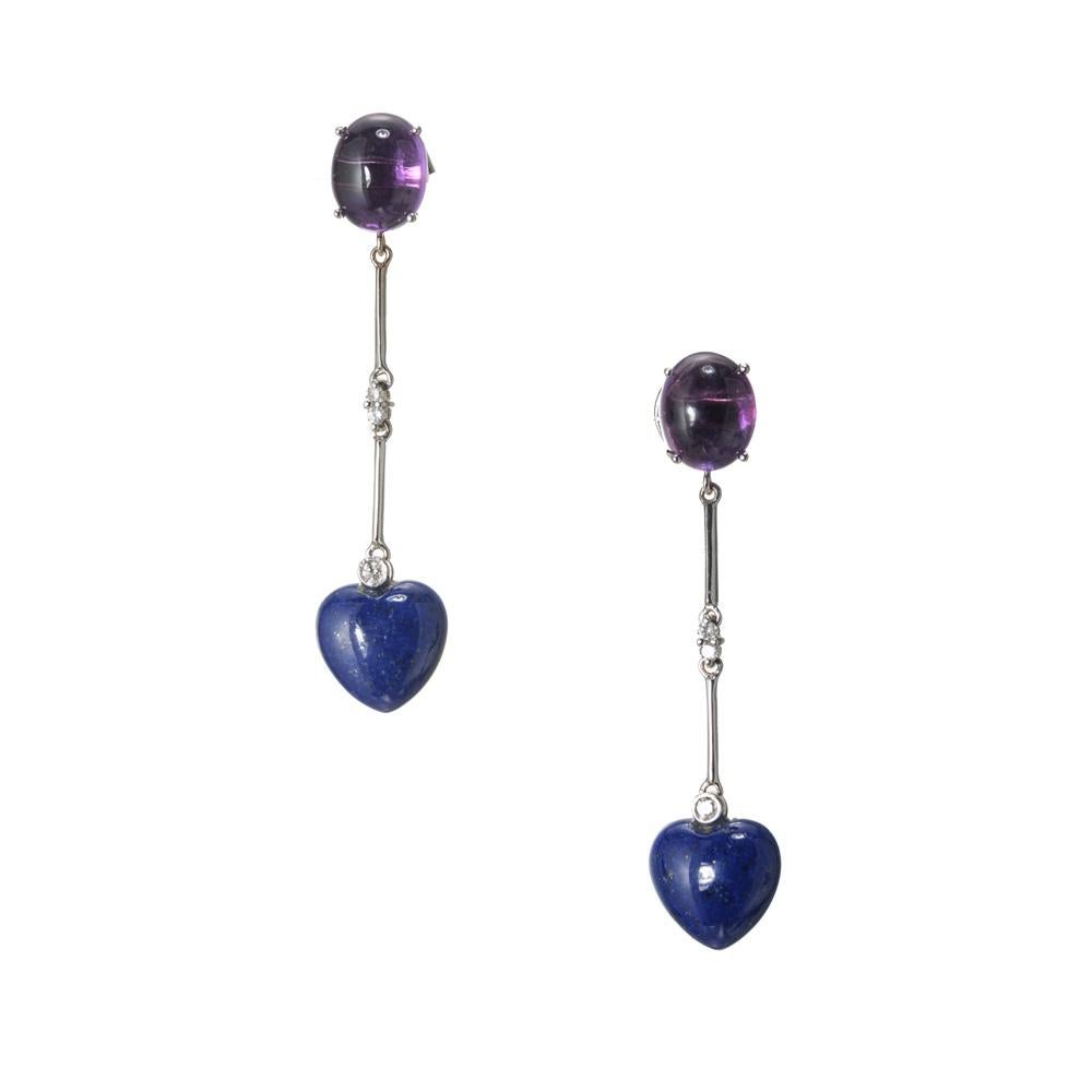 Boucles d'oreilles pendantes en lapis-lazuli, améthyste et diamant. Deux améthystes ovales cabochons, chacune avec un lapis en forme de cœur, sont montées sur de l'or blanc 18 carats.  6 diamants ronds accentués. 

2 améthystes violettes ovales en