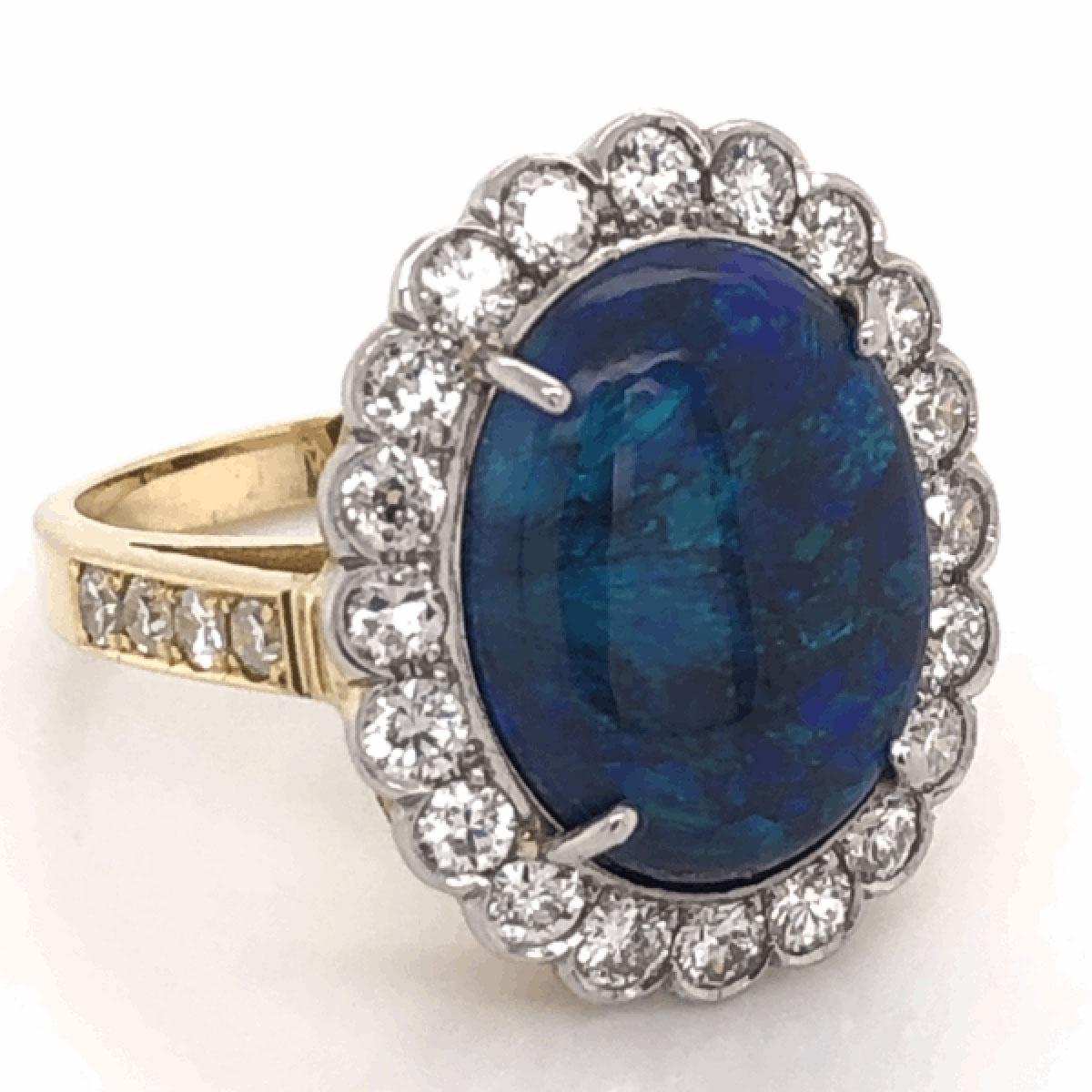 Simply Beautiful! Elegant and finely detailed Solitaire Cocktail Ring, set with a securely nestled 6.00 Carat Black Opal surrounded by Brilliant-cut Diamonds, weighing approx. 1.10 total Carat weight.  Hand crafted in Platinum on 18 Karat Gold. Size