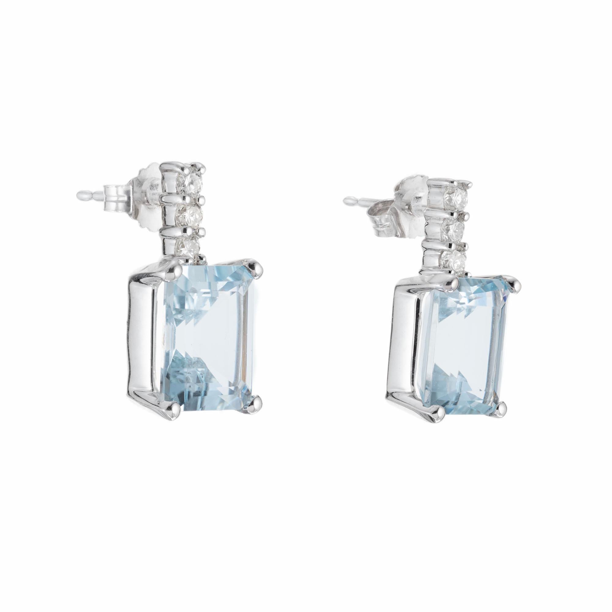 Simple aqua and diamond dangle earrings. Two beautiful greenish blue emerald cut Aquamarine's set in simple four prong settings, each with 3 full cut round accent diamonds in 14k white gold. 

2 10 x 8mm slightly greenish blue Emerald cut Aqua,