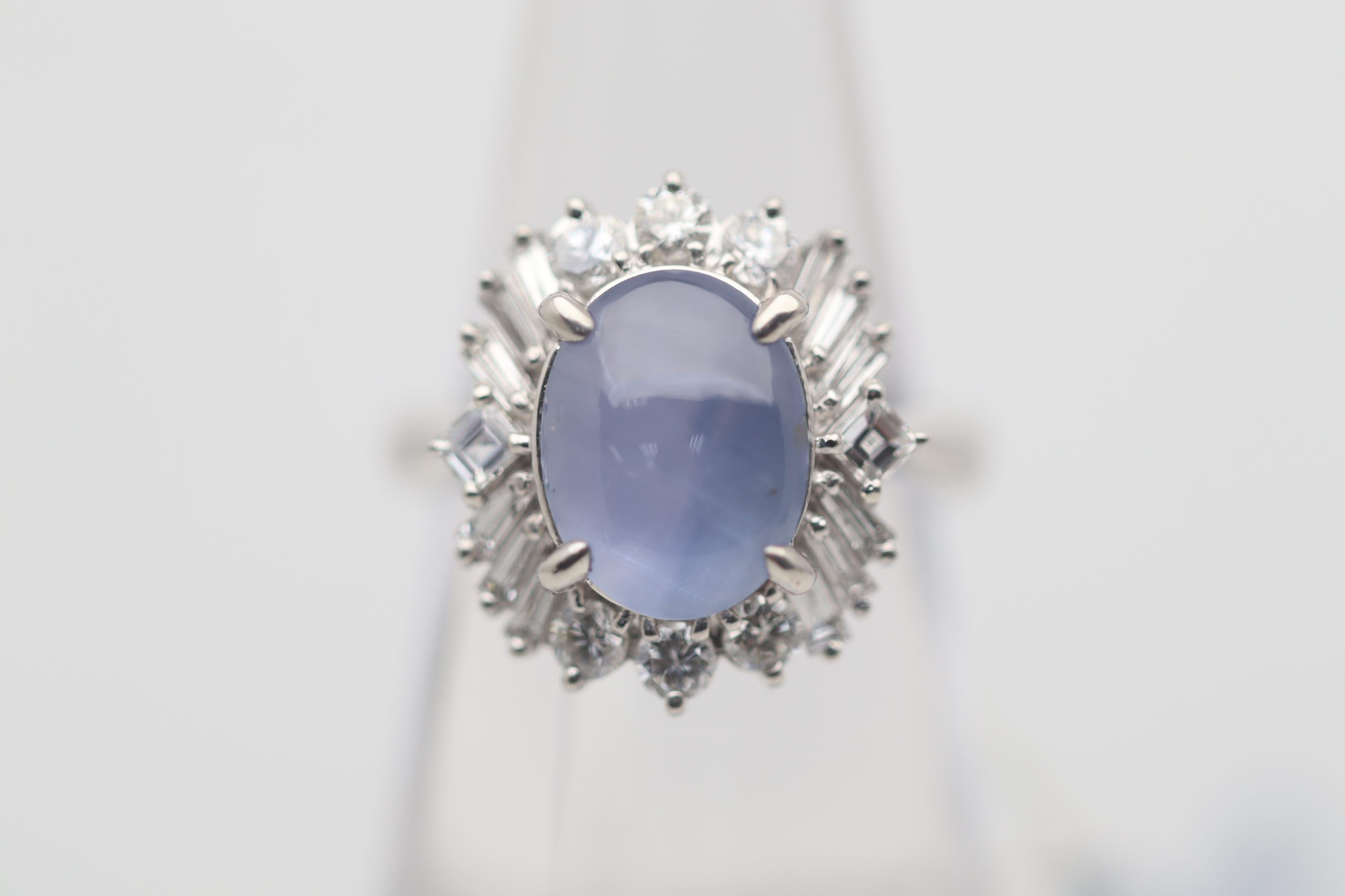 Une bague élégante et brillante ornée d'un saphir étoilé de 6,00 carats. Elle a une couleur bleue douce et uniforme et une forte étoile à 6 rayons lorsqu'une lumière frappe son sommet. Le saphir est ébloui par une variété de diamants de forme