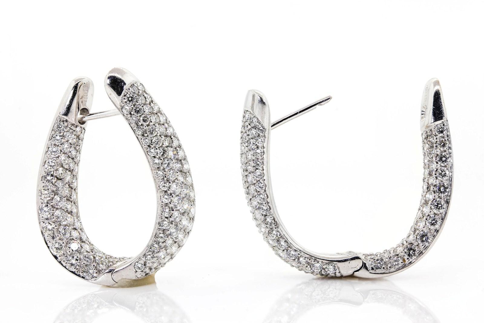 These dazzling elongated hoops are created in 18KT white gold of high brilliant quality.  They are pave set with 6.00 carats of Round Brilliant Cut Diamonds of H/I color - VS clarity.  A hinged closure makes these hoops easy to wear, and the best is