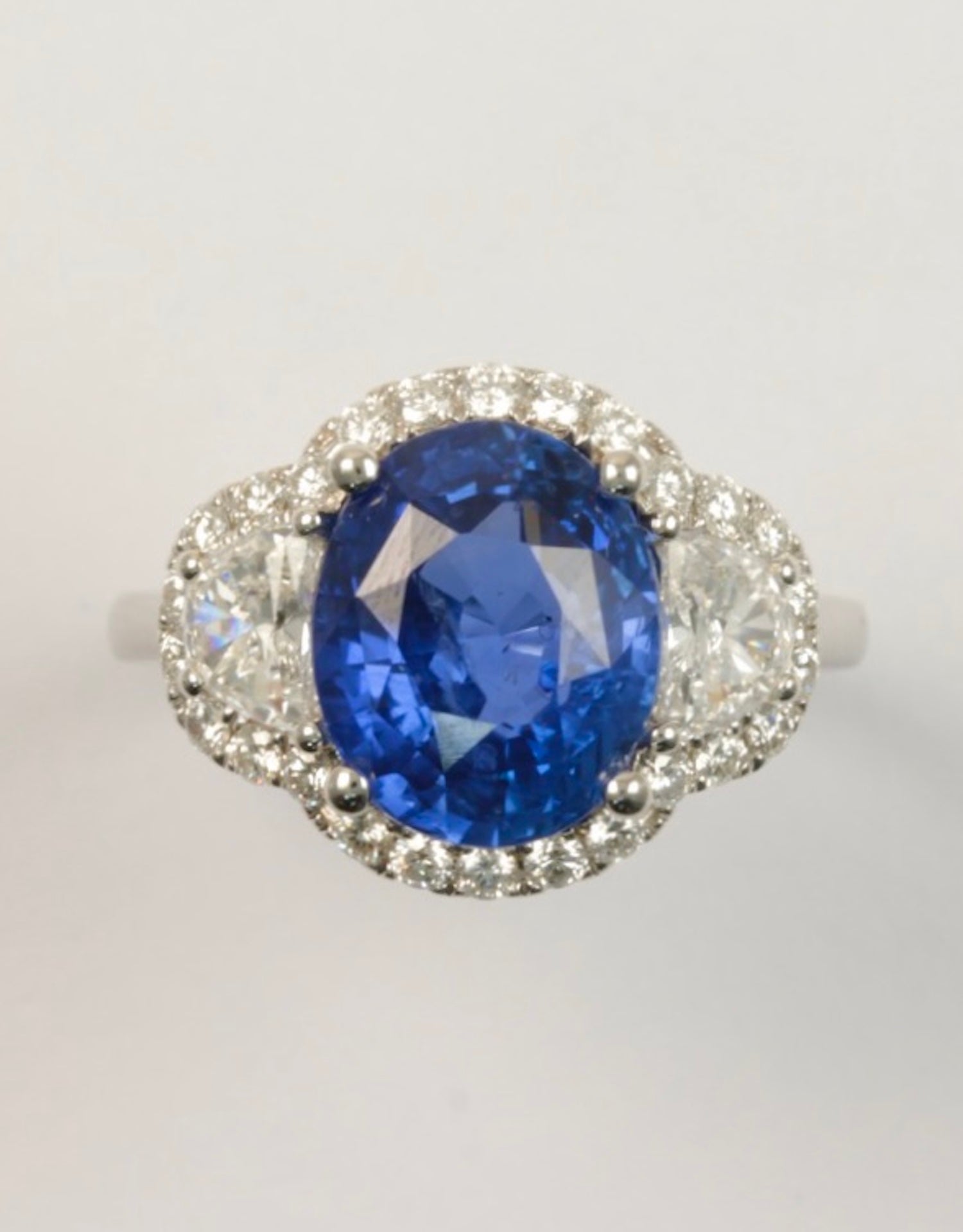 Due to its natural vibrant color, this unheated 6.00 carats sapphire from Sri Lanka is very rare by nature and of the most desired quality.

In this spectacular ring, the blue sapphire is flanked by half-moon diamonds with a combined weight of 0.68