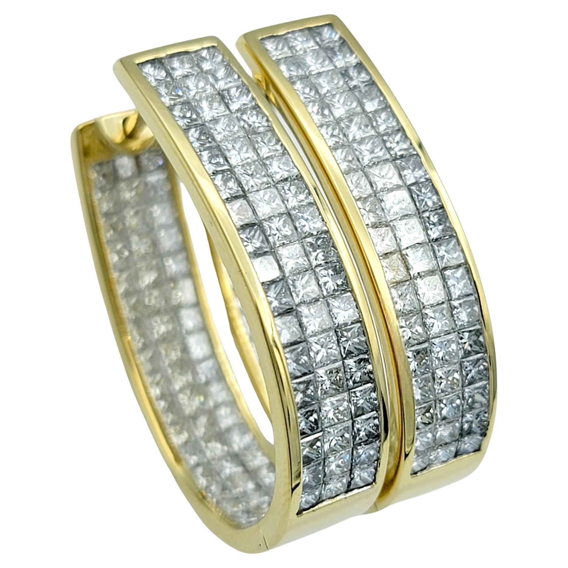These diamond hoop earrings epitomize luxury and sophistication with their elegant design and exquisite craftsmanship. Crafted in 18 karat yellow gold, each hoop features three rows of dazzling princess-cut diamonds, invisibly set to create a