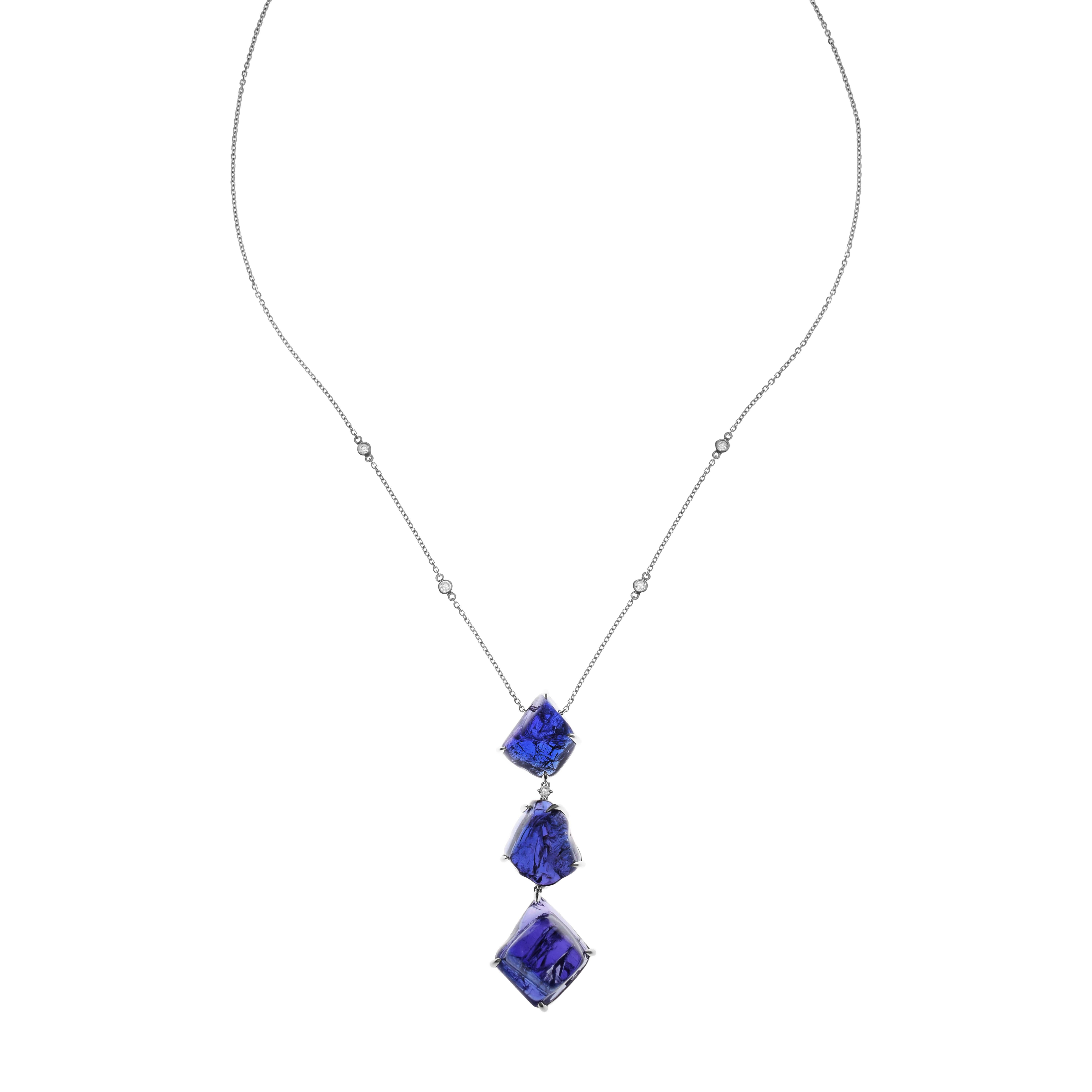 Diese wunderschöne Halskette besteht aus drei Tansaniten, die jeweils einzigartig geschliffen sind und von zwei weißen Diamanten getrennt werden, die alle in Weißgold gefasst sind. Die Edelsteine hängen an einer Weißgoldkette, die mit vier weißen
