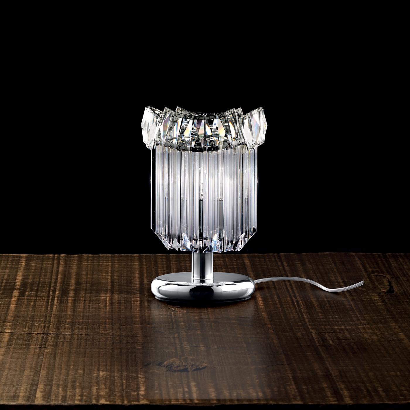 An opulent table lamp, unique in its simple, essential design that results in a very fancy piece. It is made in T1 lead crystal and it uses either 3 E14 energy saver lamps or 3 E14 LED lamps. It is available in either the chrome or the 24-karat gold