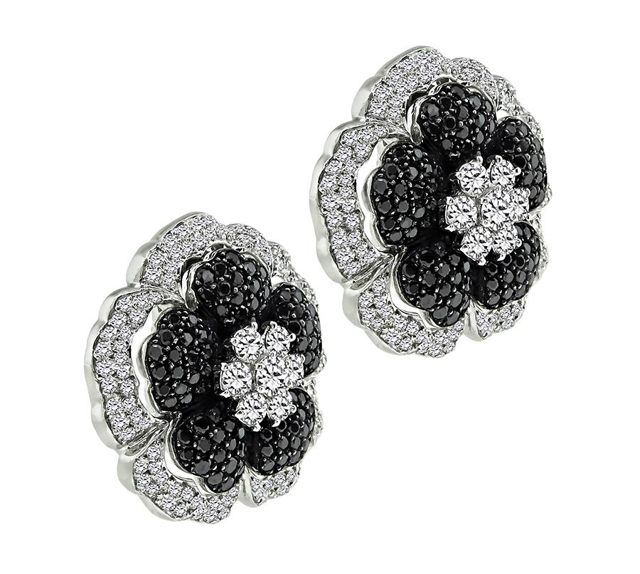 This is an elegant pair of 18k white gold flower earrings. The earrings feature sparkling round cut black and white diamonds that weigh approximately 3.50ct and 6.00ct respectively. The color of the white diamonds is G with VS clarity. The earrings