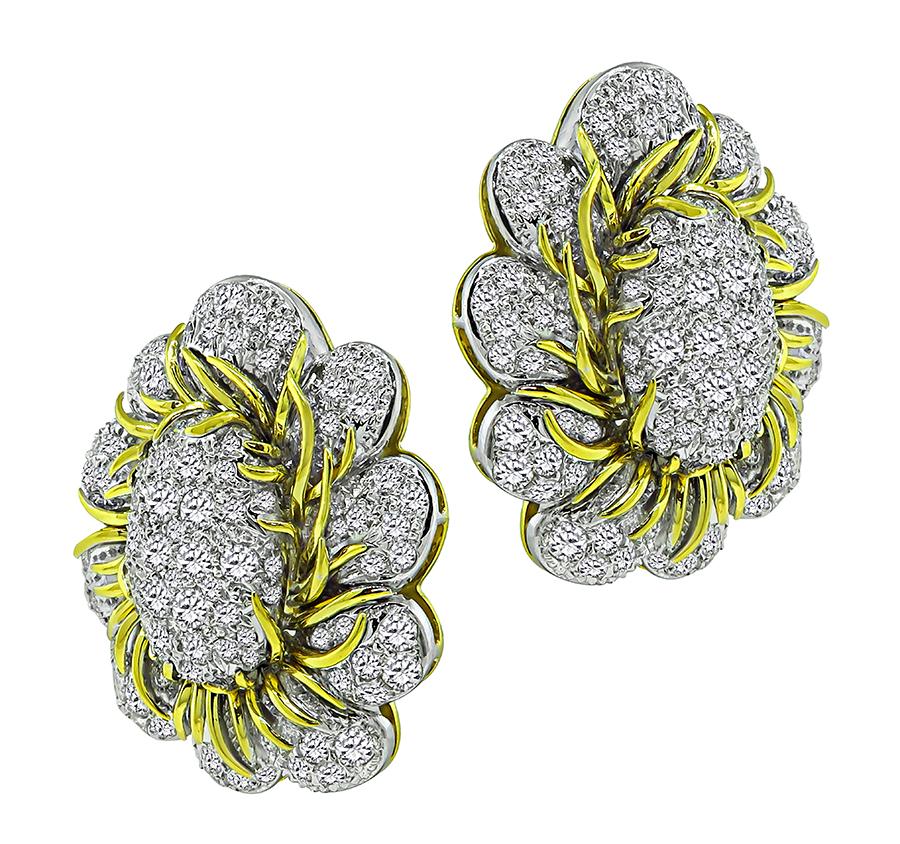 This is a stunning pair of 18k yellow gold and platinum earrings. The earrings feature sparkling round cut diamonds that weigh approximately 6.00ct. The color of these diamonds is G with VS clarity. The earrings measure 33mm by 28mm and weigh 31.5