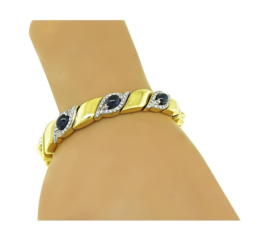 This is an amazing 18k yellow gold bangle. The bangle is set with lovely cabochon sapphires that weigh approximately 6.00ct. The sapphires are accentuated by sparkling round cut diamonds that weigh approximately 0.30ct. The color of these diamonds