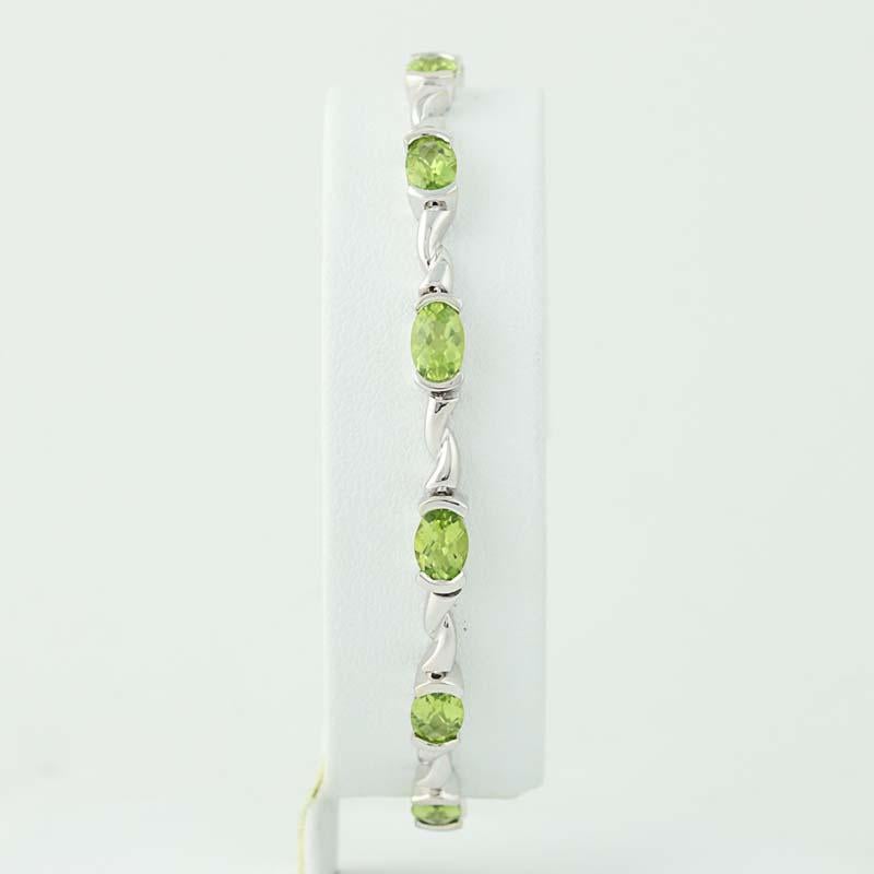 Add a refreshing splash of color and shine to your attire with this fabulous bracelet! Featuring a link-style design, this bracelet showcases twelve radiant peridot gemstones set in 14k white gold. 

Metal Content: Guaranteed 14k Gold as