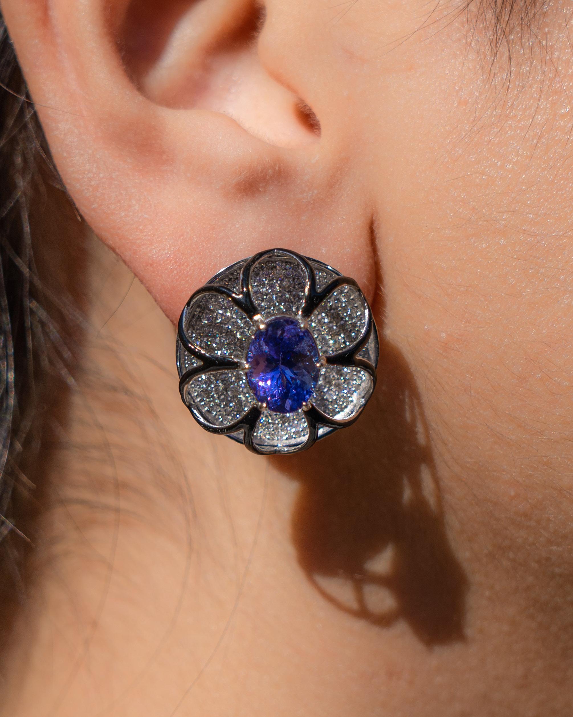 A very unique pair of art-deco 6.01 carat oval shaped Tanzanite and 2.83 carat Diamond studs, with black enamel, all set in solid 18K White Gold. The earrings come with an omega clip, making it a secure fastening. 
We provide free shipping, and we