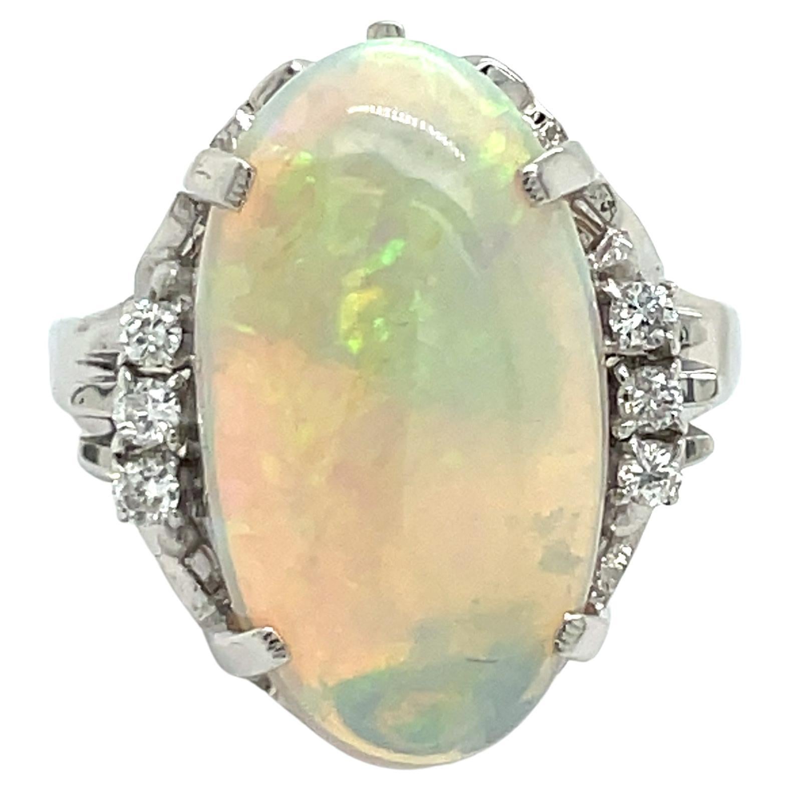 Large classic styled 6.01 ct oval opal, diamond and platinum ring.  Just the right size for a right hand ring. This one of a kind opal shines brilliantly at every angle, reflecting an array of colors.  Set in 9.50 grams of platinum.  Surrounded by