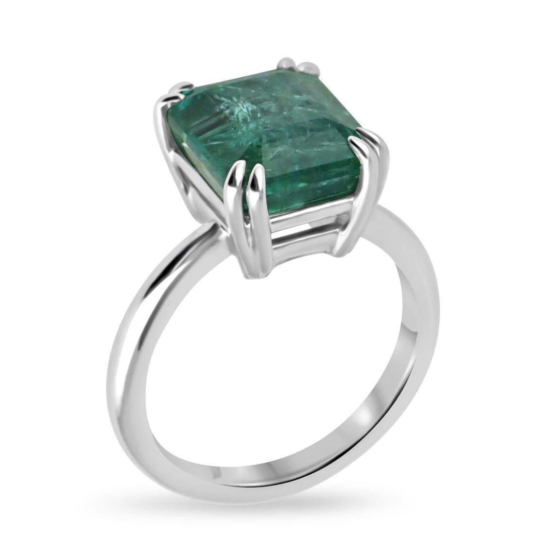 Cette exquise bague de fiançailles solitaire en émeraude met en valeur une étonnante émeraude taillée en émeraude de 6,01 carats, rayonnant d'une teinte vert profond avec des inclusions internes naturelles qui soulignent son caractère unique. La