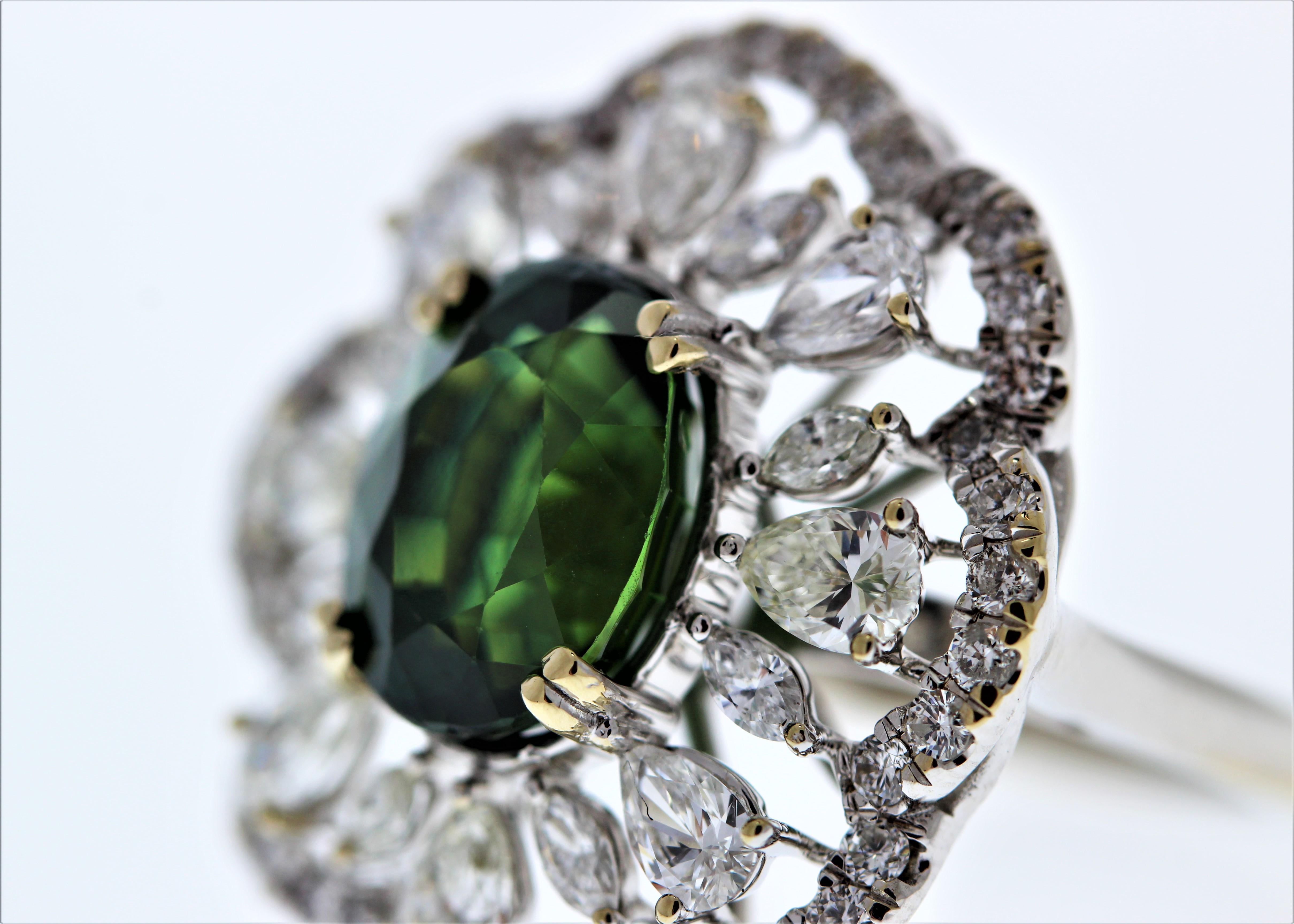 This unique halo cocktail ring features a oval cut green sapphire weighing 6.01carat. This green sapphire takes center stage in a 14k White Gold  setting. Its gem source is Sri Lanka; its transparency and luster are excellent. A total of 58 mixed