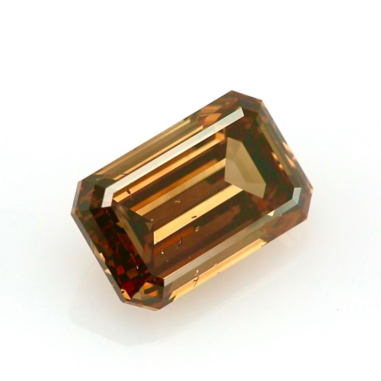 Strikingly rare and undeniably bold, this 6.01-carat Fancy Dark Orange-Brown diamond offers a rich and captivating presence unlike any other. Expertly cut in a classic emerald shape, the stone showcases clean lines and broad facets that highlight