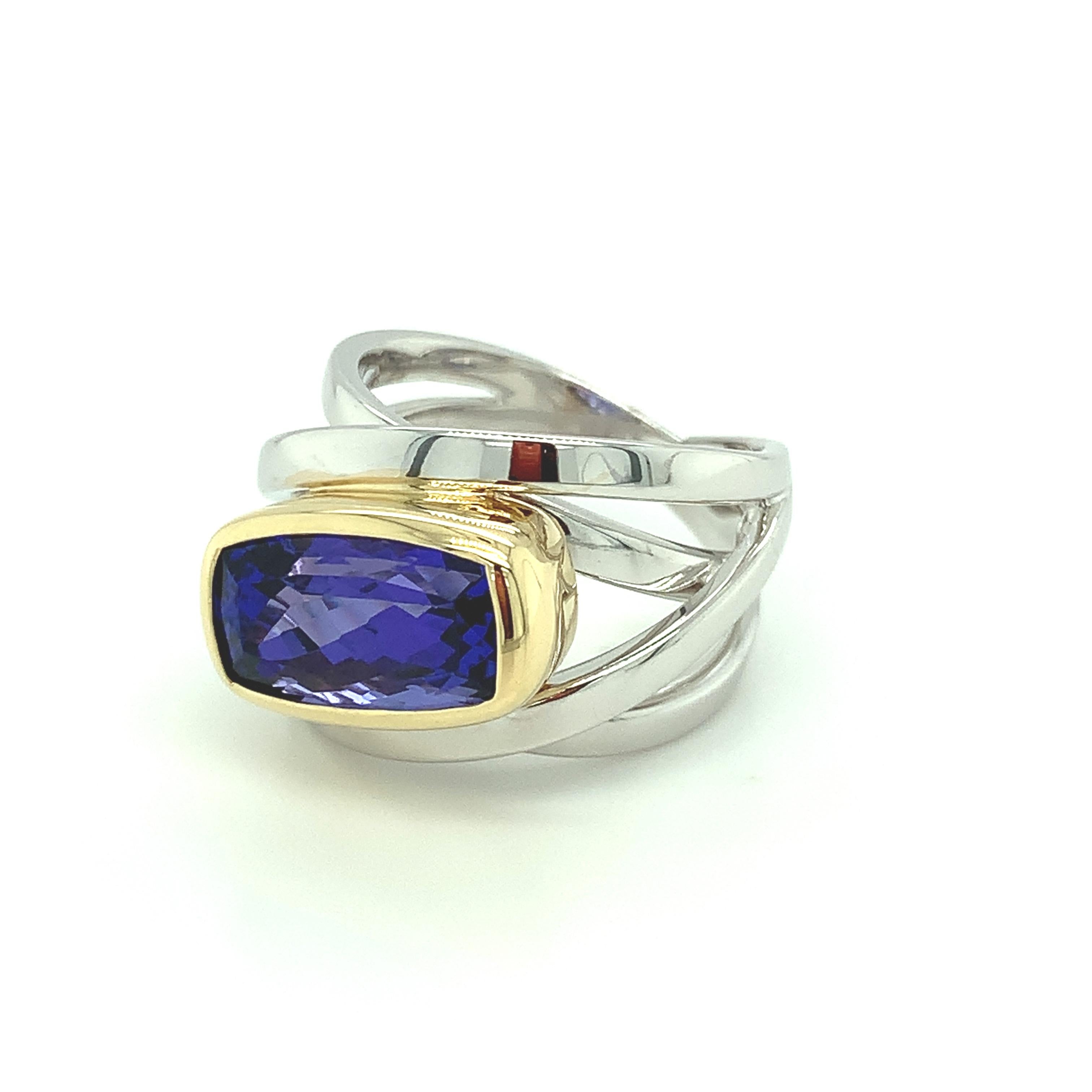 A 6.02 carat gem tanzanite the color of African violets is bezel set in our chic and stylish wraparound band ring. This ring is a versatile and seamless design that can be worn any time of day or night, whether you're working from home or out