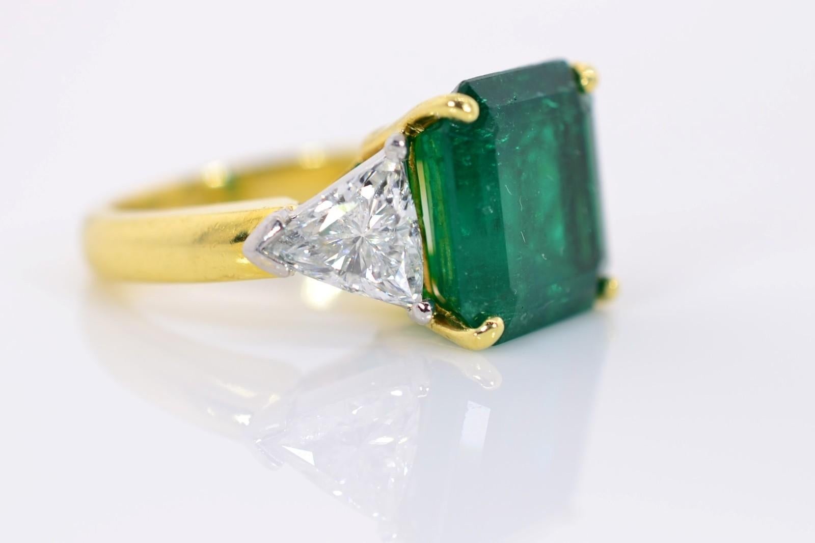An Emerald ring--always classic and desirable!  This ring is a beautiful example, a 6.03 carat deep green Emerald certified by A.G.L.  Report No. 1105190 of Colombian origin and with minor enhancement.   The Emerald is flanked by two Trillion cut