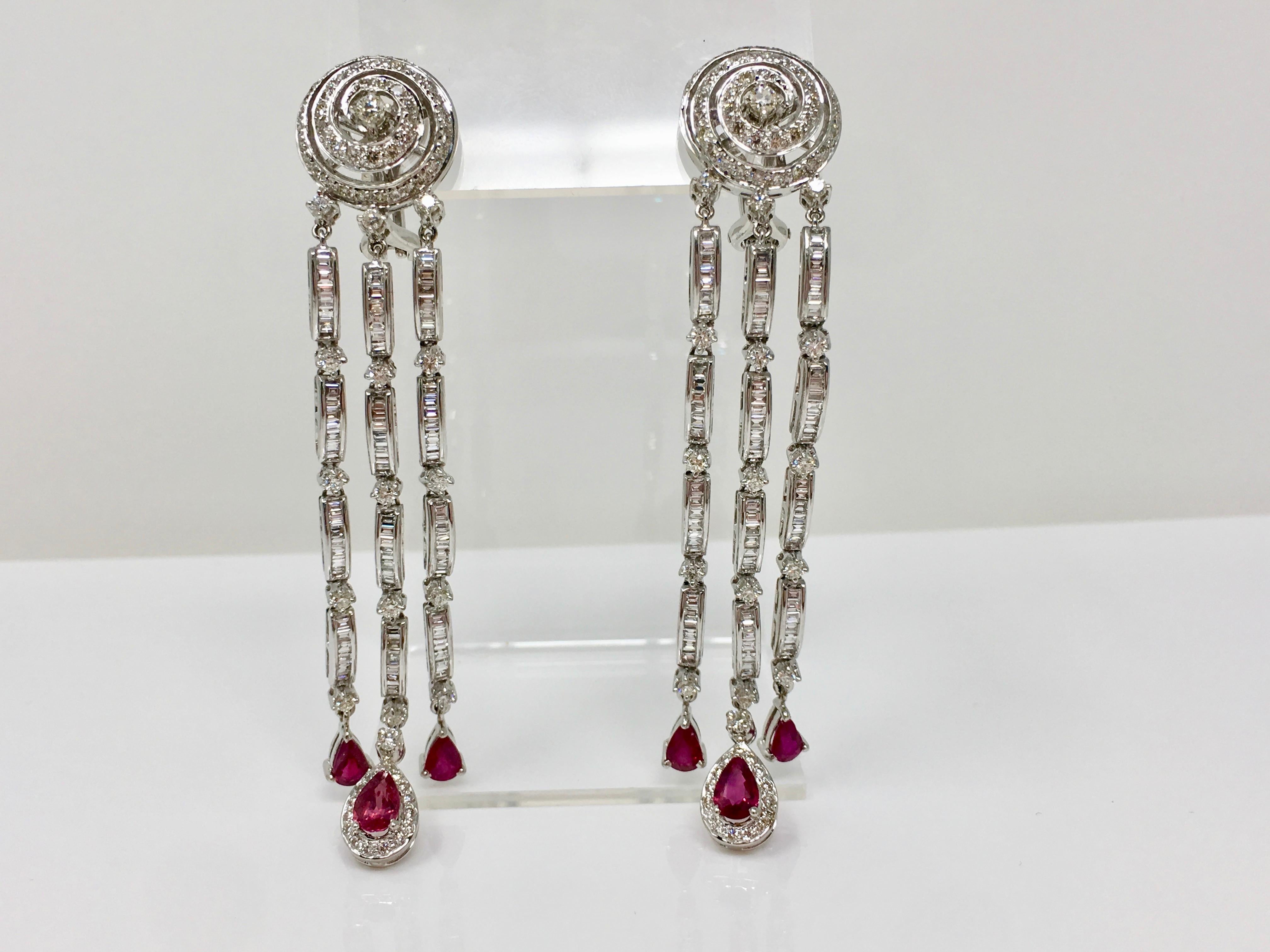 Un paio di orecchini in oro bianco 18 carati, diamanti e rubini della collezione MOGULDIAM INC, con diamanti bianchi rotondi a brillante del peso di 6,03 carati con colore GH e purezza VS e splendidi rubini rossi del peso di 3,40 carati. Questi