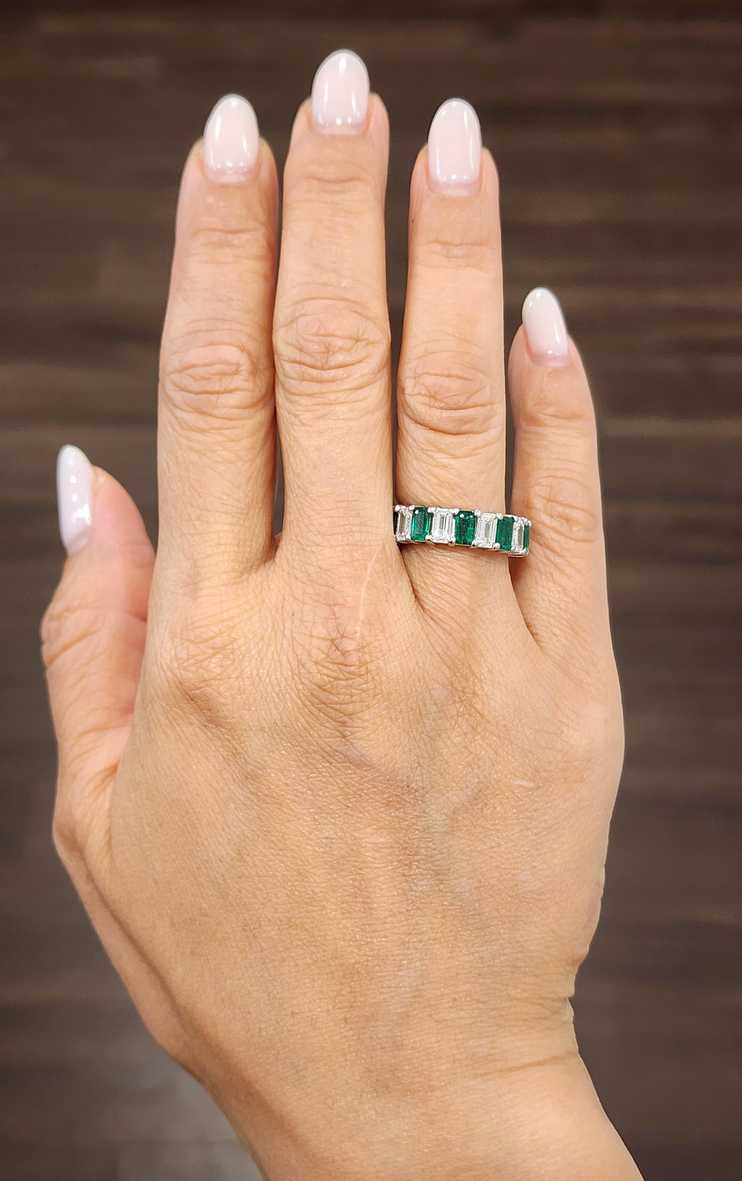 This exquisite eternity band showcases a mesmerizing pairing of natural Colombian emeralds and emerald-cut white diamonds, creating a design that is both timeless and sophisticated. The rich green hue of the emeralds contrasts beautifully with the