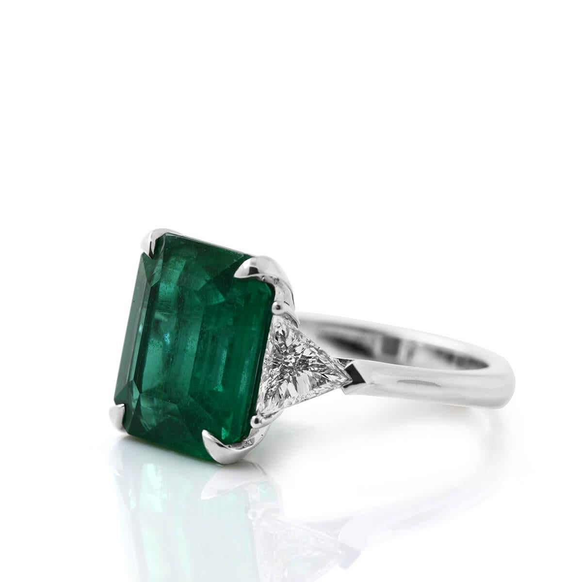 This contemporary piece hosts a natural unheated 6.34 Carat Natural Green Emerald and has natural white diamonds around the band, making up a total of 7.29 Carats. 
According to ancient myths, emeralds were thought to guard against memory loss and