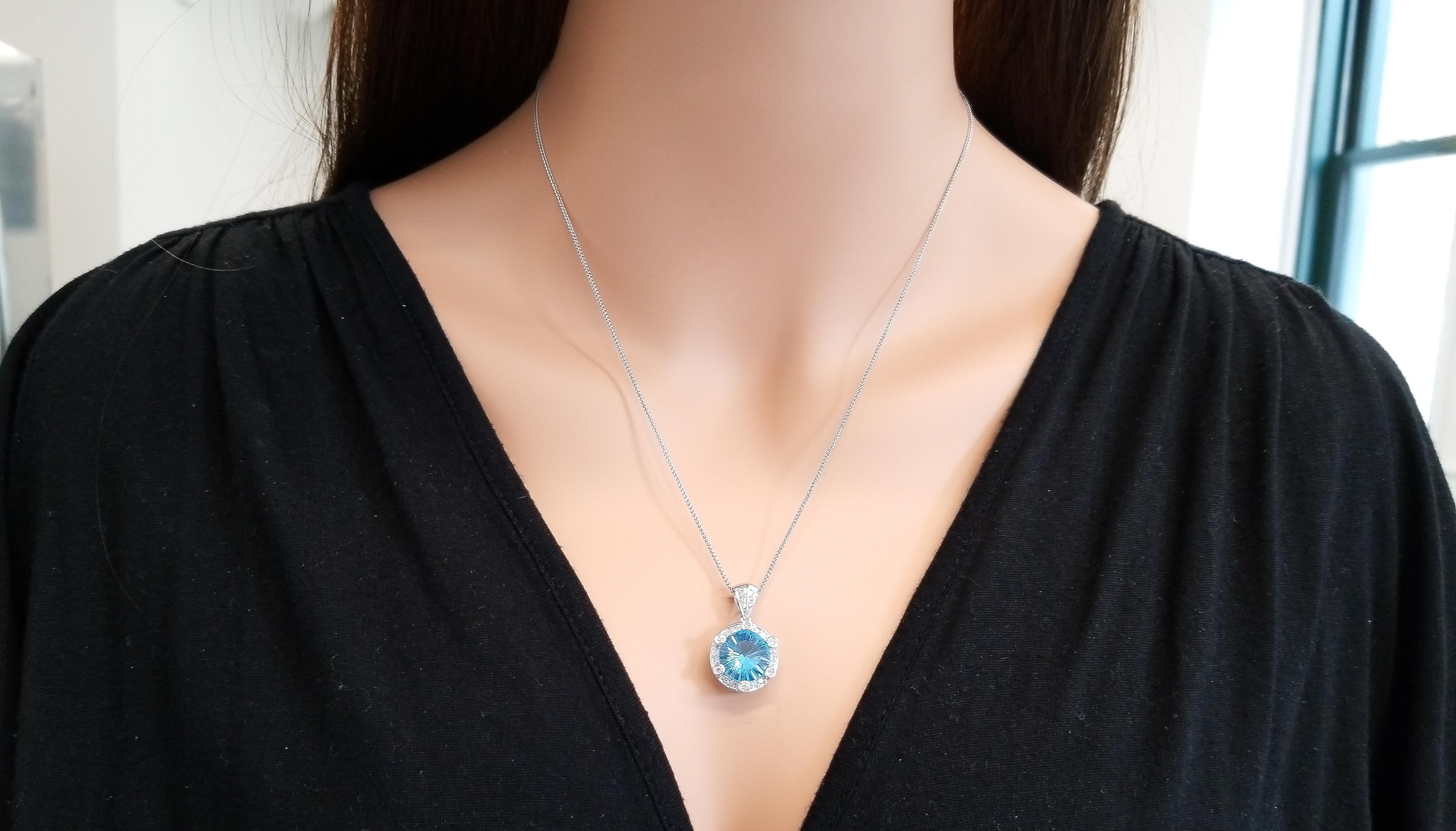 Reminiscent of a bright blue sky, this is a gorgeous Swiss blue topaz necklace. A 6.05 carat round fantasy cut Swiss blue topaz is prong set and skillfully cut with a starburst pavilion. Its gem source is Brazil and measures 11.50mm round. Its
