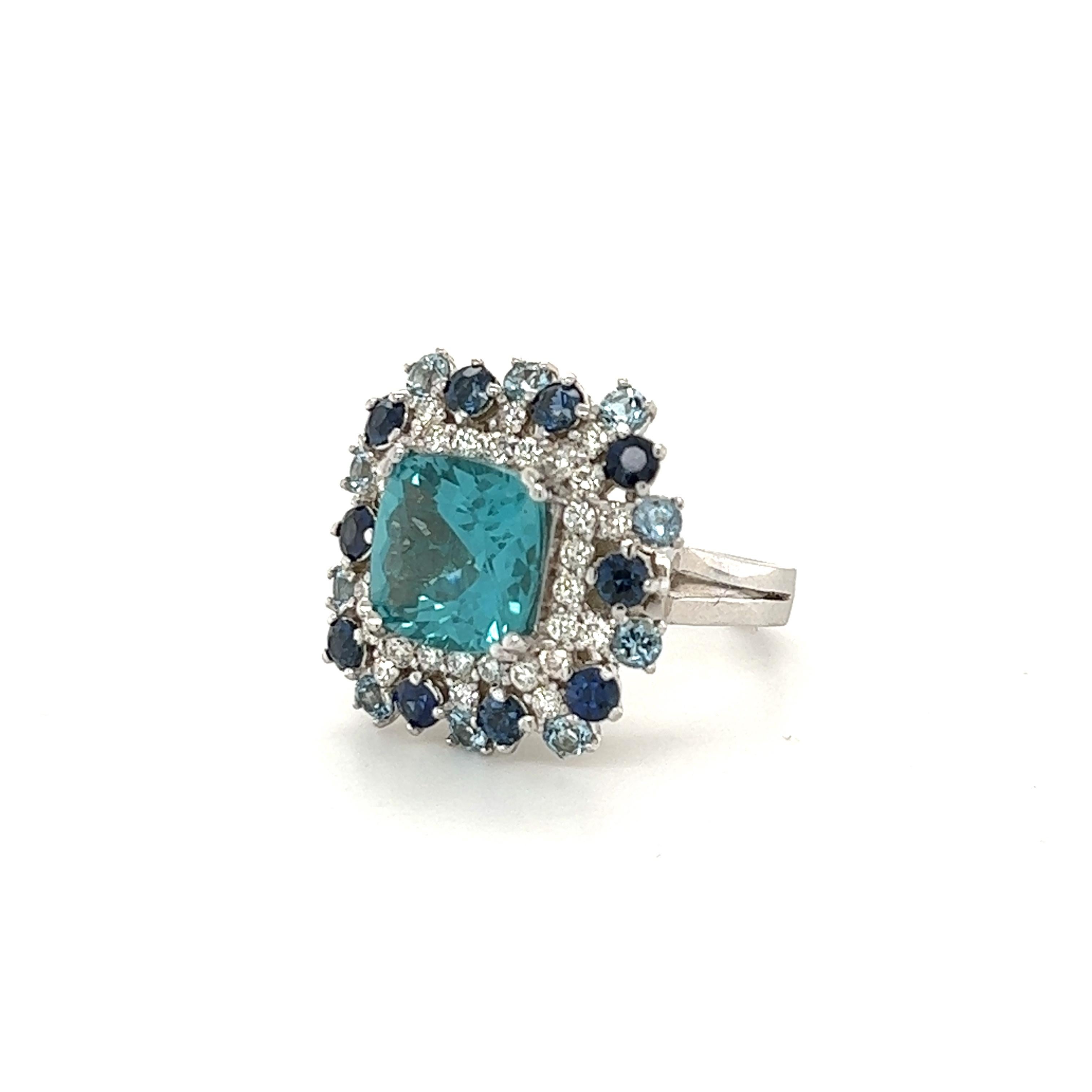 This ring has a beautiful Cushion Cut Natural Apatite that weighs 4.23 carats. There are Natural Round Cut Blue Sapphires that weigh 1.17 carats and 10 Natural Round Cut Aquamarines that weigh 0.66 carats. There are also 32 Round Cut Diamonds that