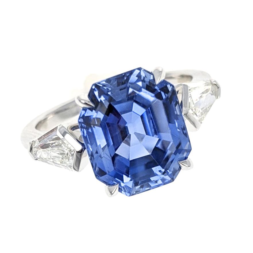 This stunning ring centers upon an octagonal step-cut sapphire of 6.06 carats and is accompanied by an SSEF report dated 02/04/2019 stating that the sapphire is from Ceylon (Sri Lanka) with no indications of heating. The sapphire is flanked by two