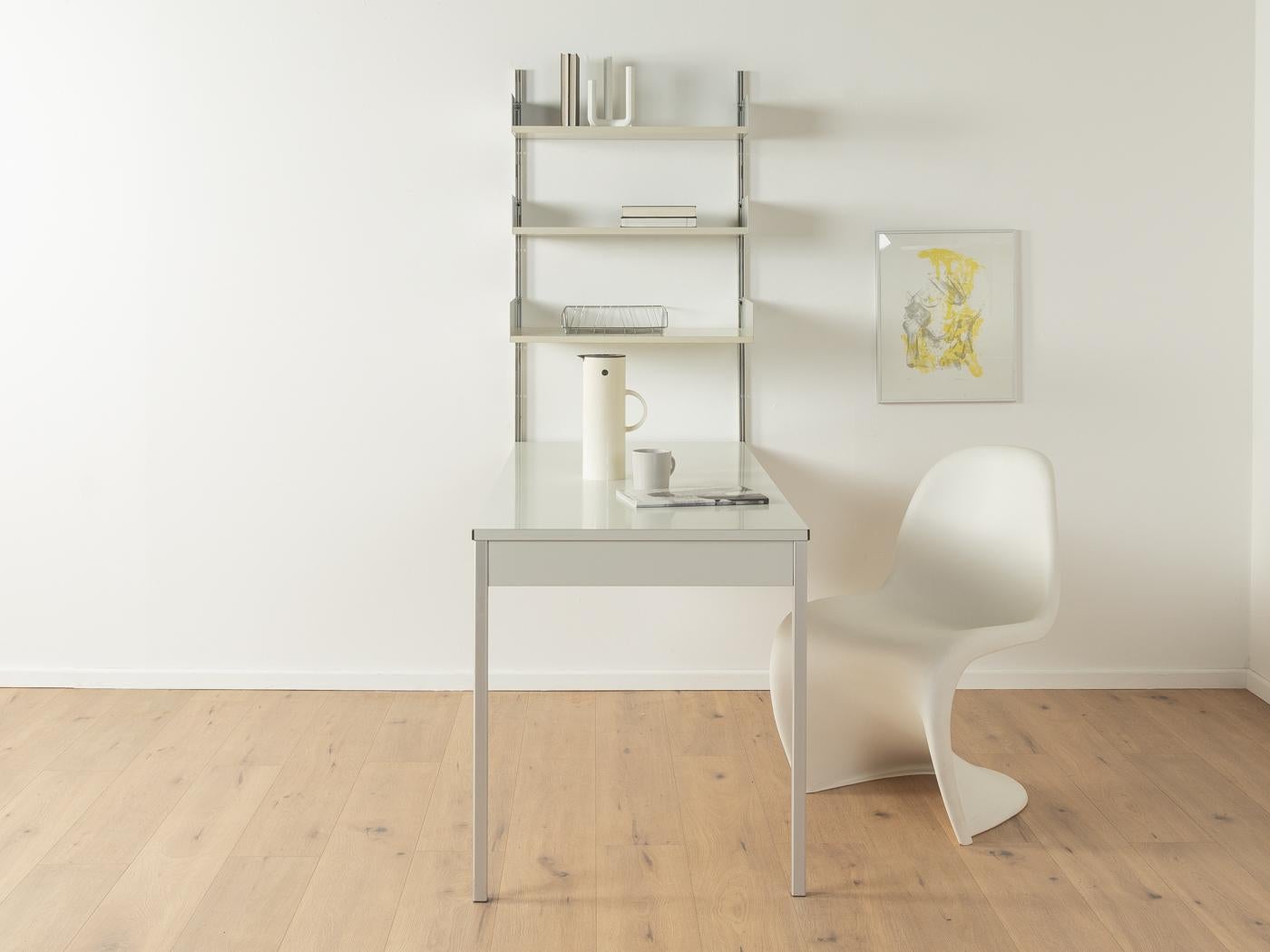 Modular shelving system 606 by Dieter Rams for Vitsœ from the 1960s. High-quality construction consisting of two aluminum E profiles, three shelves and rare RZ-57 integrated table with aluminum legs. 
Quality Features:

    very good workmanship
   