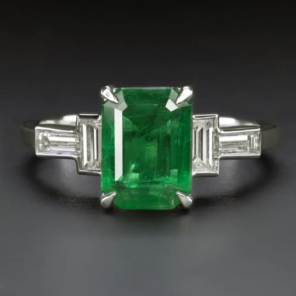 This exquisite ring showcases a magnificent 6.07ct natural emerald, flanked by a pair of tapered baguette diamonds, in a high-quality platinum setting. The emerald, with its stunning rich green color, captivates with eye-catching size and a lively